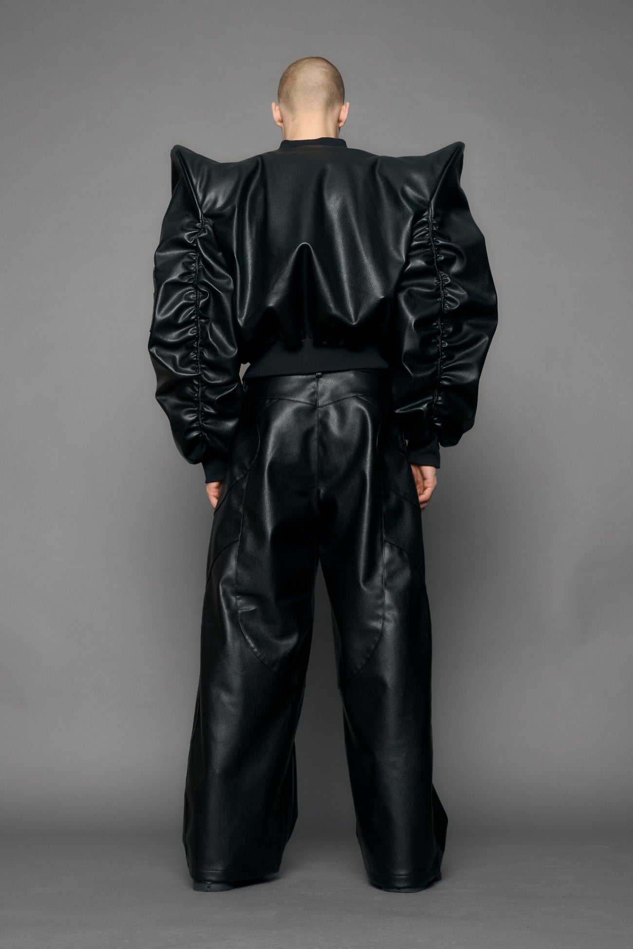 model wearing black pu leather bomber jacket with sharp shoulder design