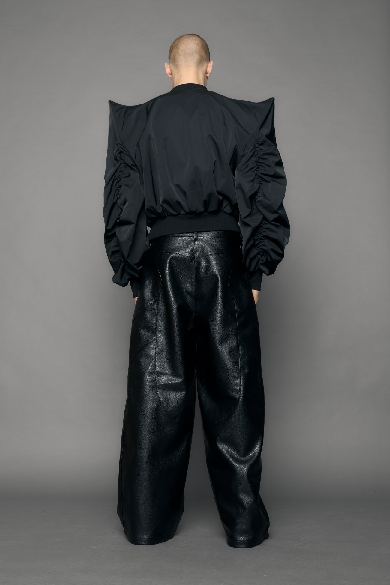 model wearing black bomber jacket with sharp shoulder design