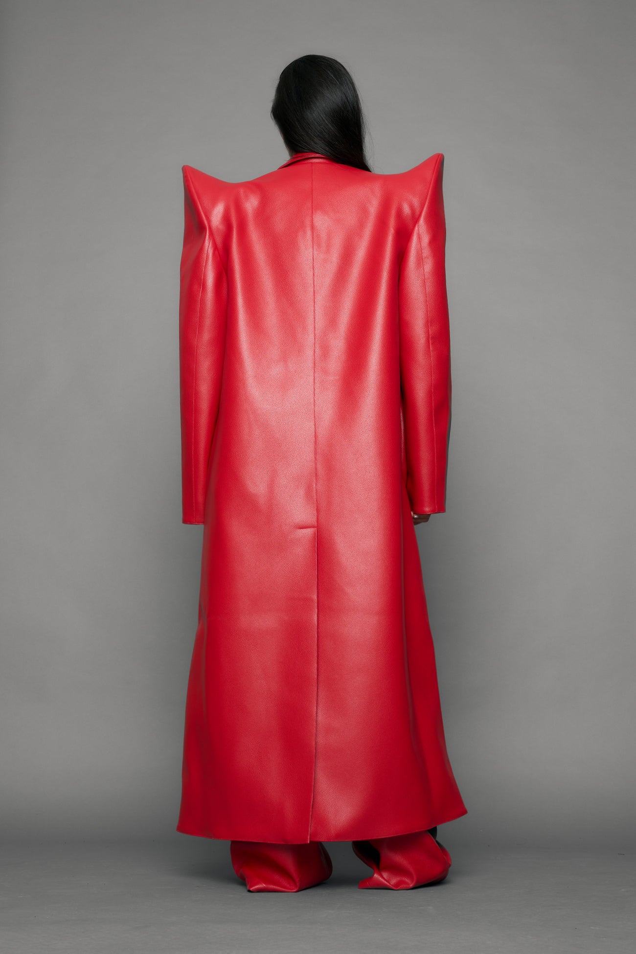 model wearing red pu leather coat with sharp shoulder design