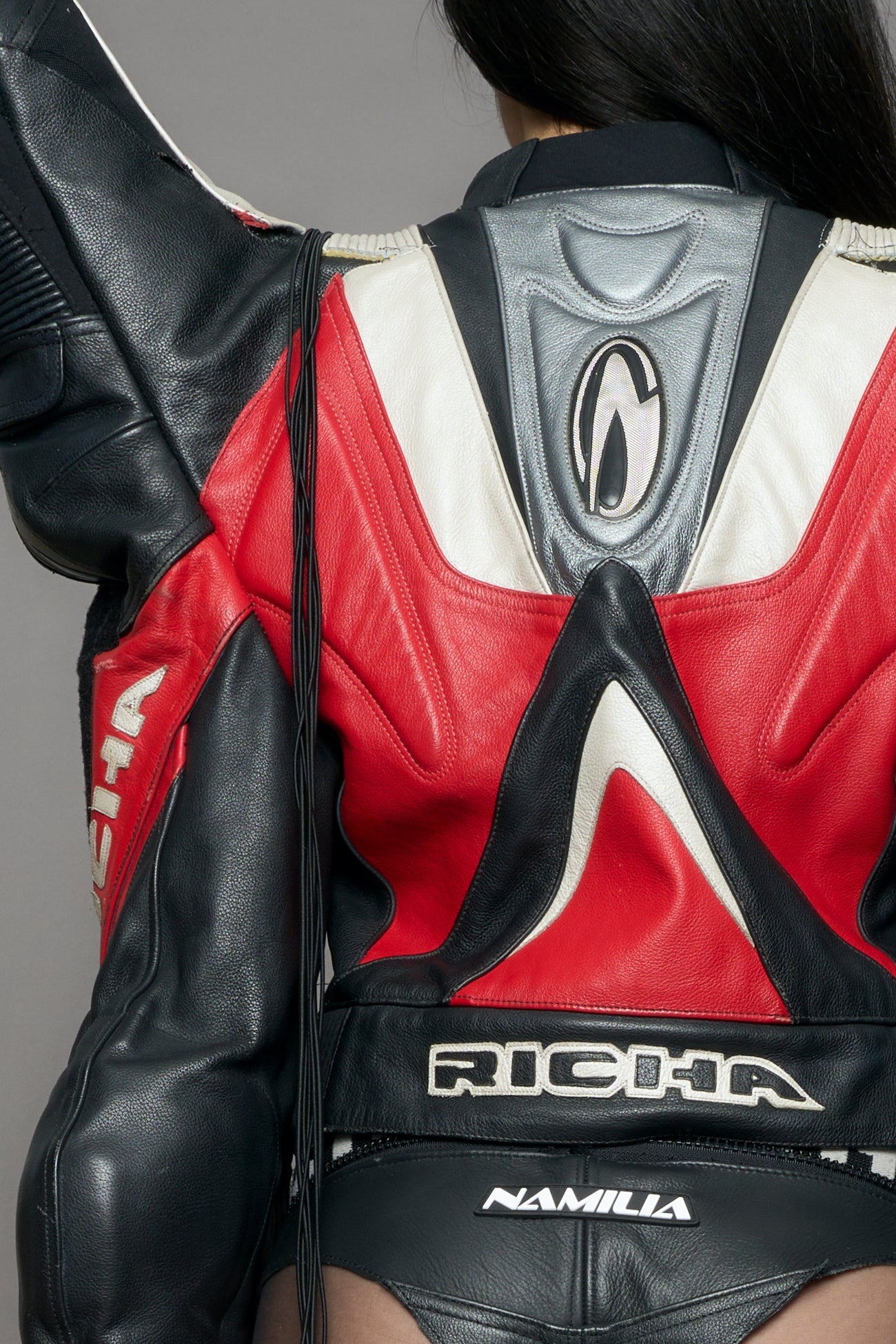 model wearing a motocross jacket with red and black accents on a gray background