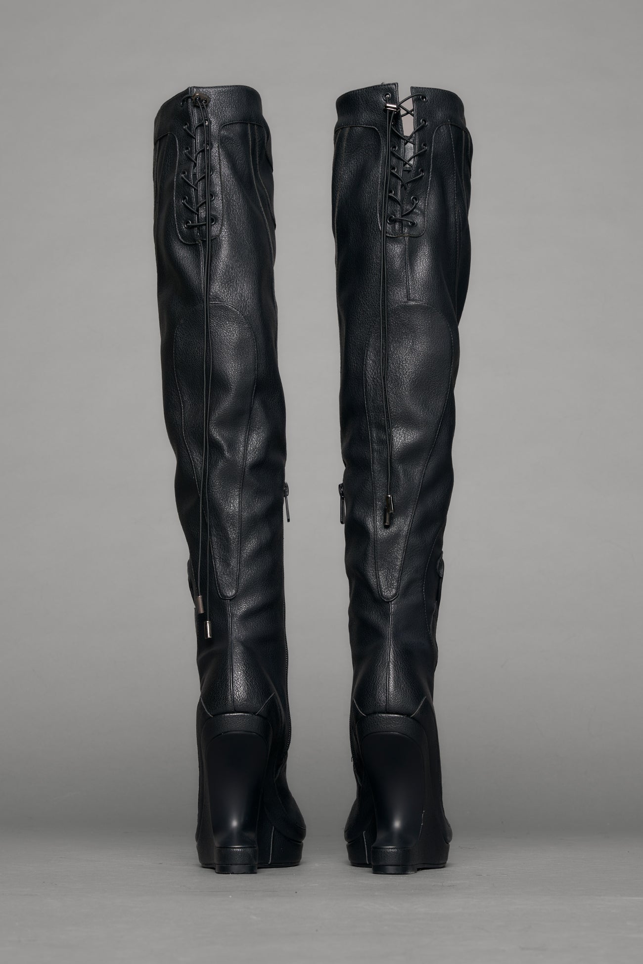 Black leather wedge boot on a gray background