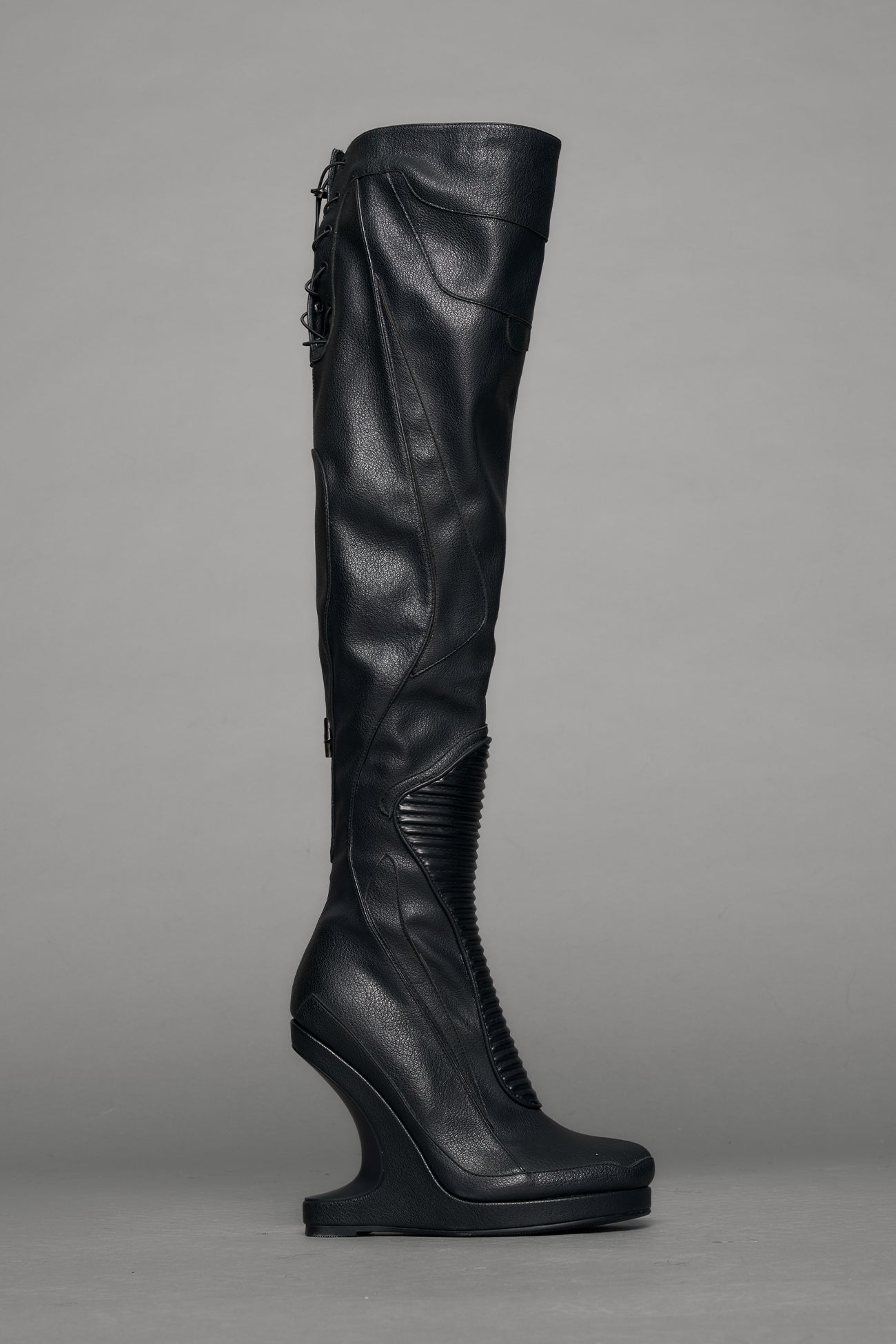 Black leather wedge boot on a gray background