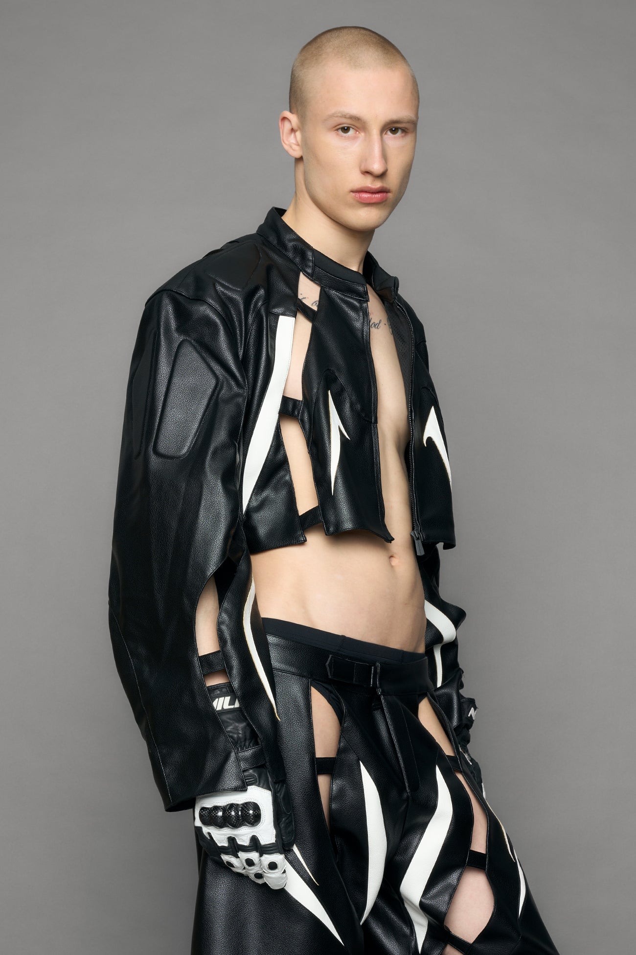 model wearing black and white moto pu leather jacket with cut out design