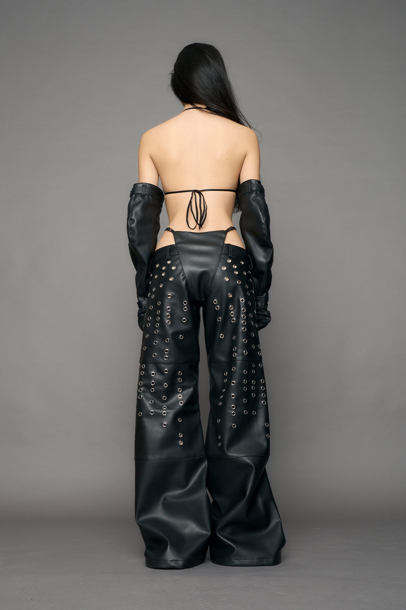 model wearing black pu leather pants with eyelet details