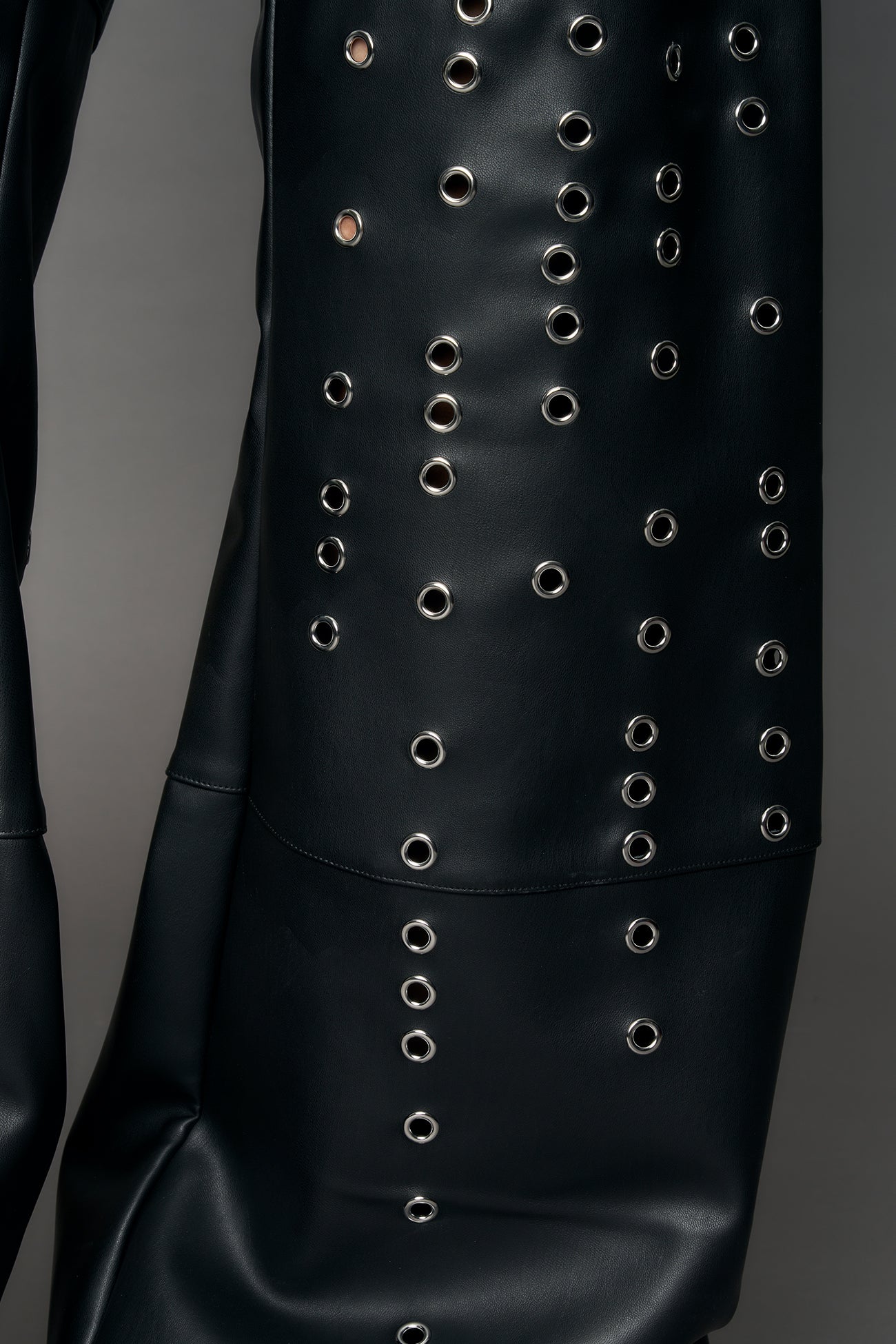 model wearing black pu leather pants with eyelet details