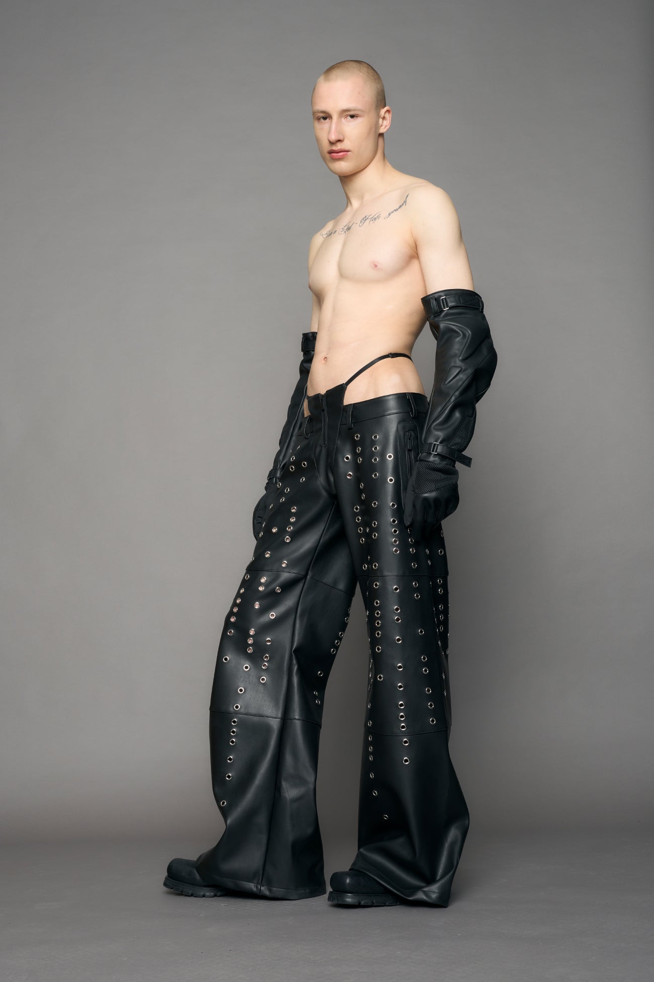 model wearing black pu leather pants with eyelet details