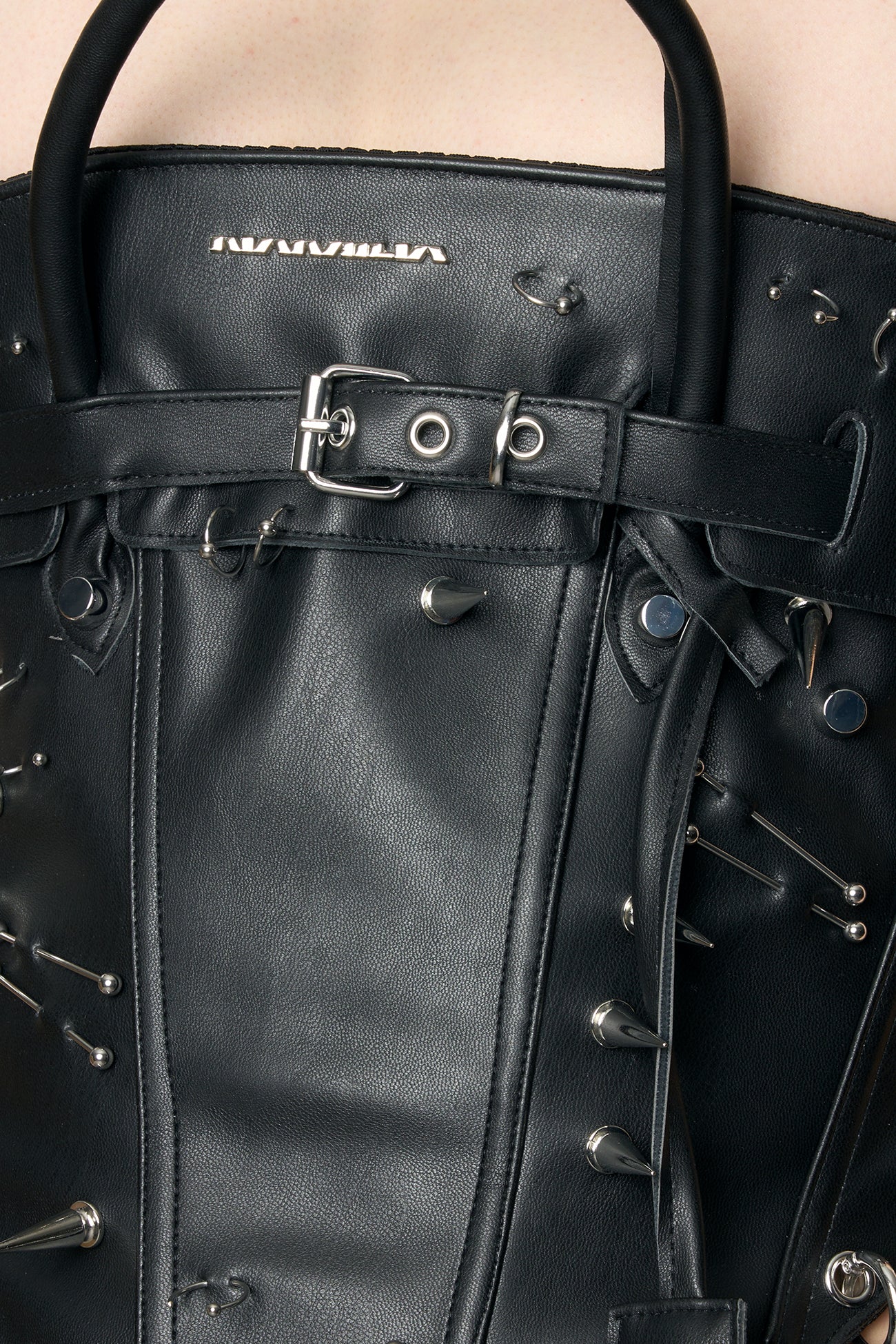 model wearing black studded handbag corset
