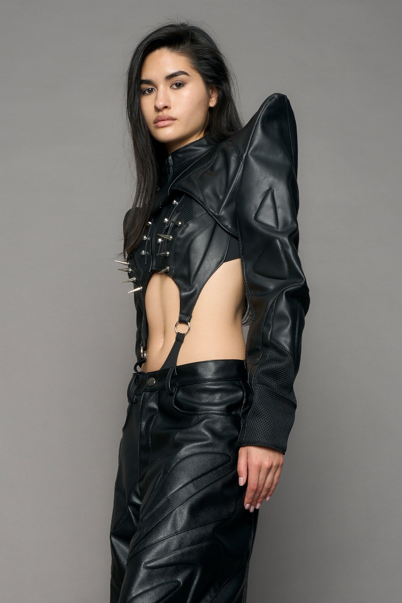 Model wearing a black leather choker jacket with cut-out design
