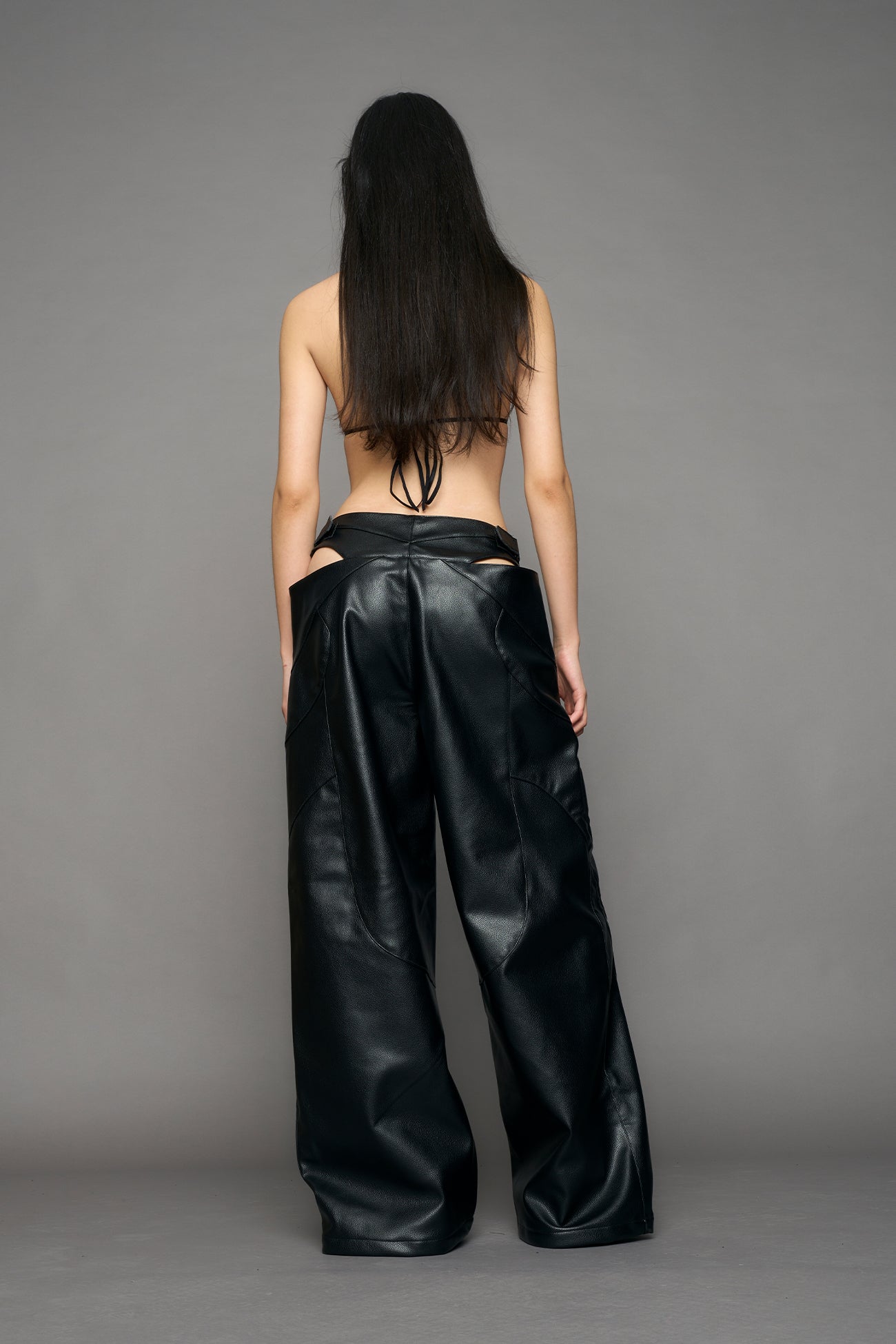 model wearing black pu leather trousers with thong design and moto style highlights