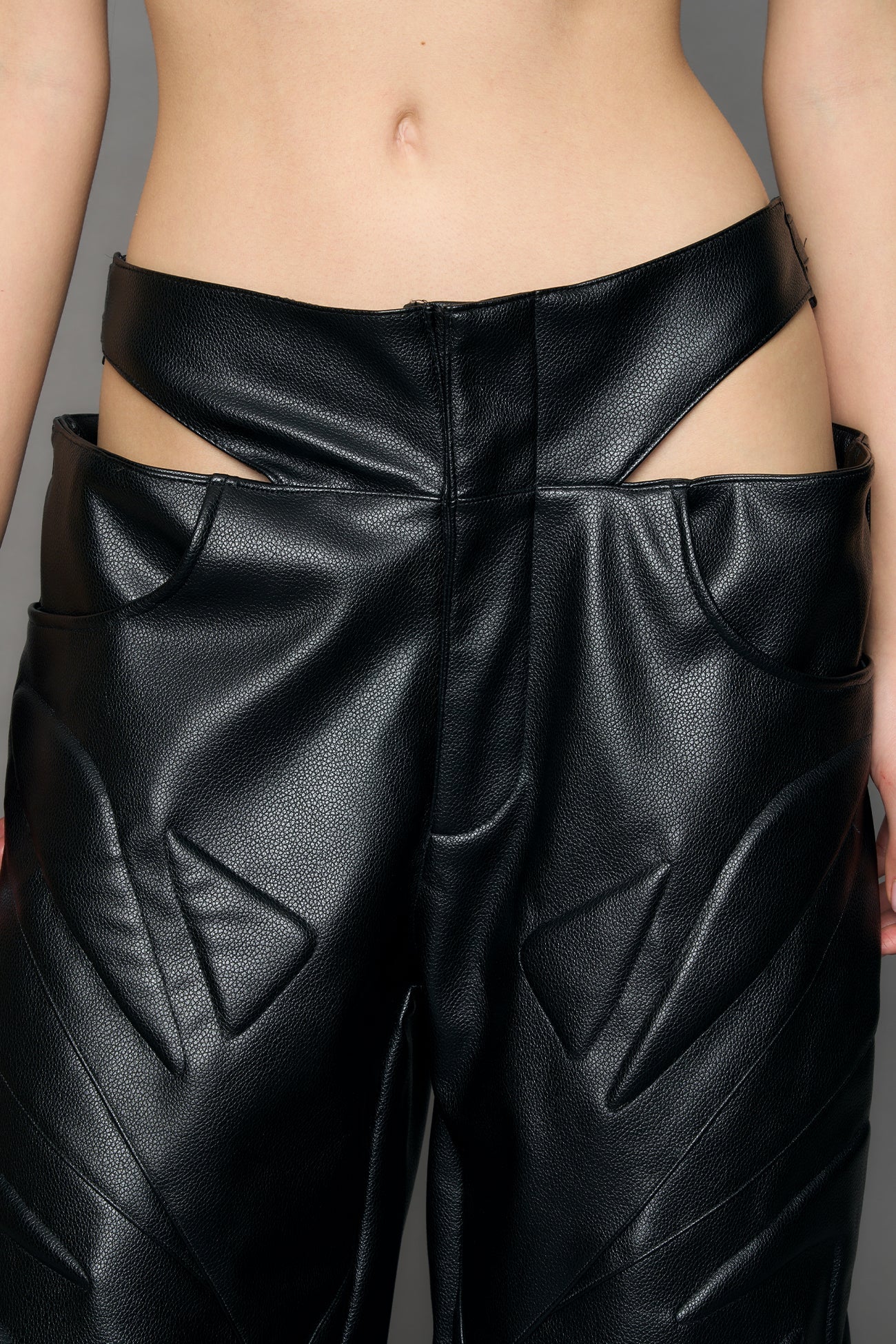 model wearing black pu leather trousers with thong design and moto style highlights
