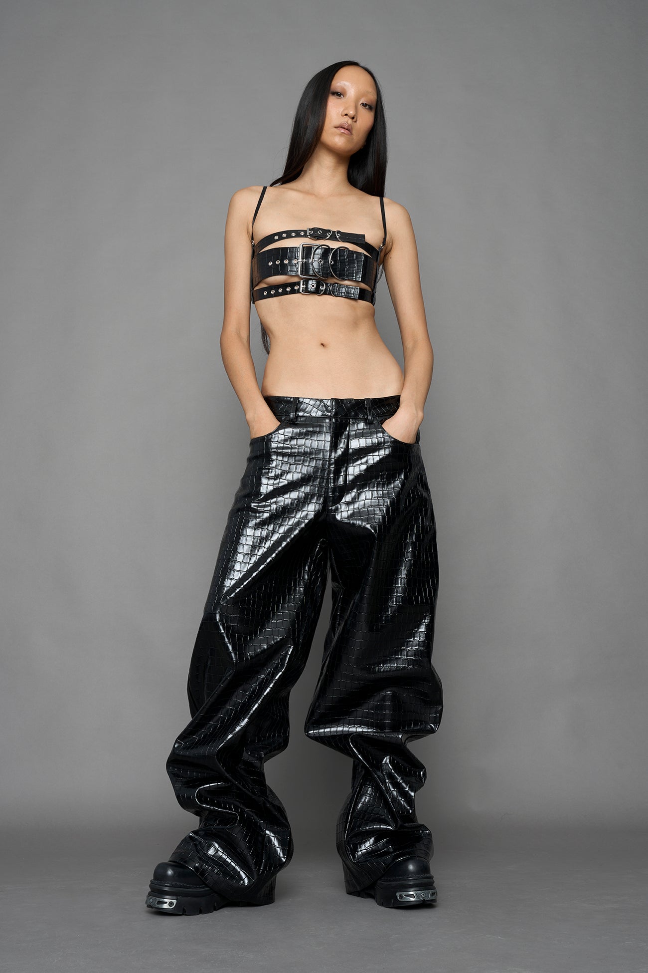 model wearing black vegan leather croc inspired belt top with buckle details