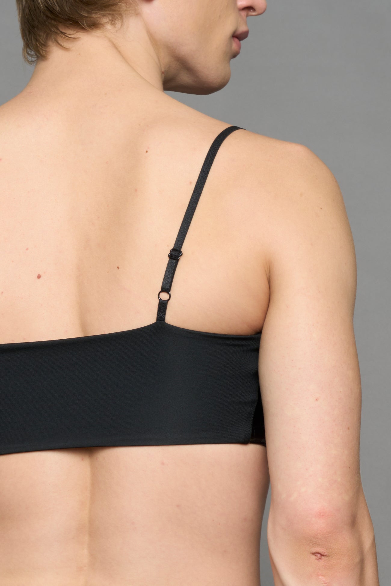 model wearing black vegan leather croc inspired belt top with buckle details