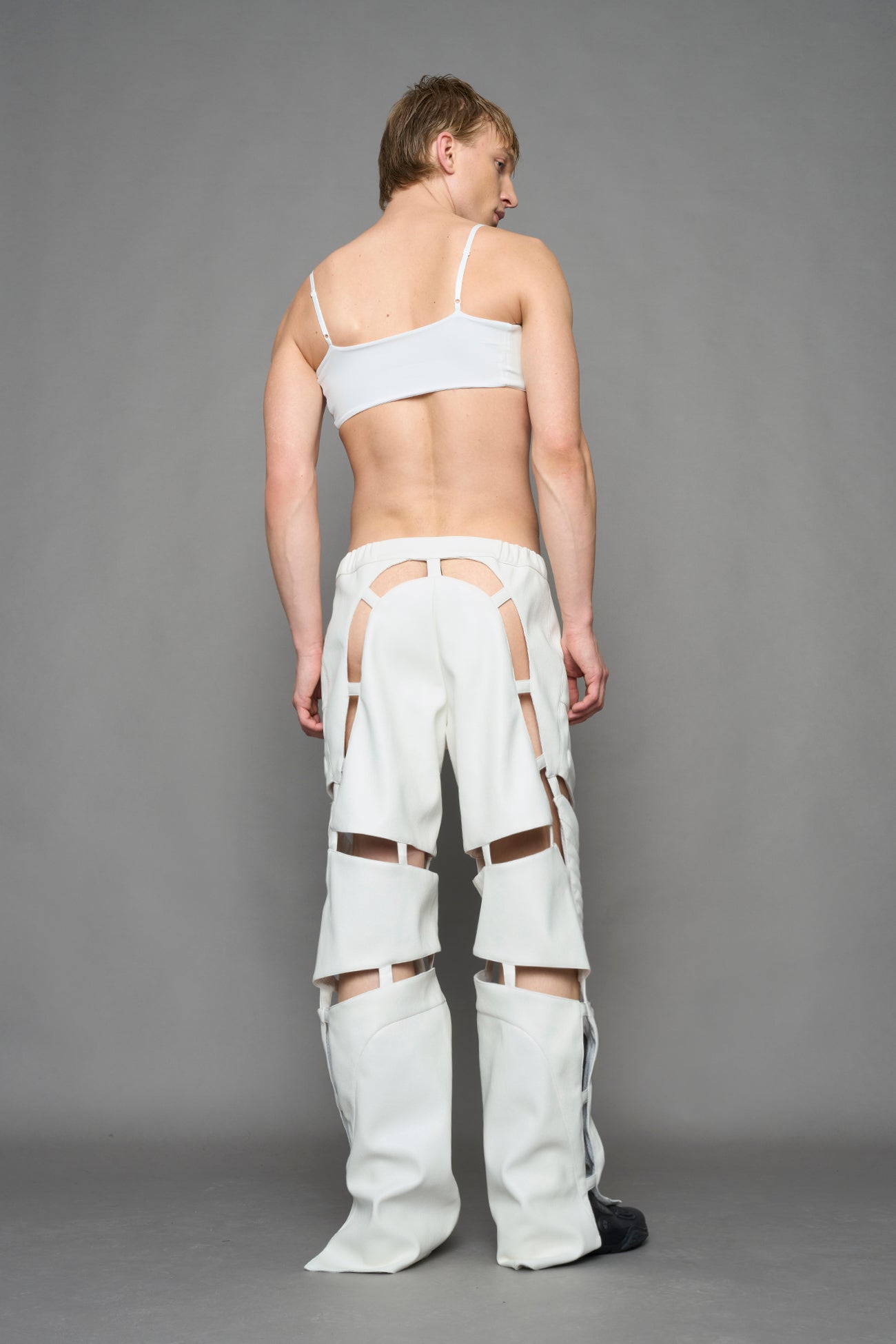 model wearing white vegan leather pants with cut out details