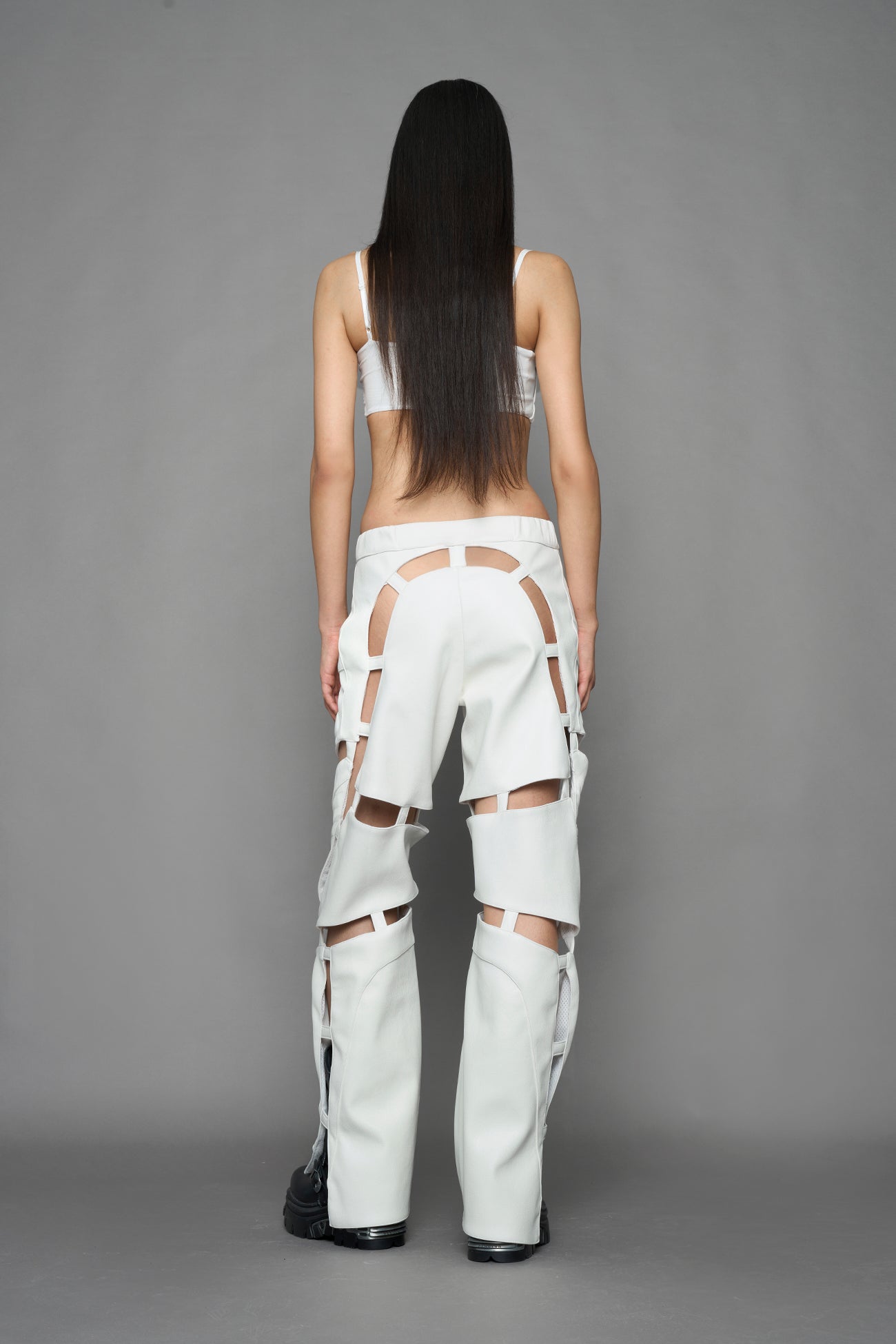 model wearing white vegan leather pants with cut out details