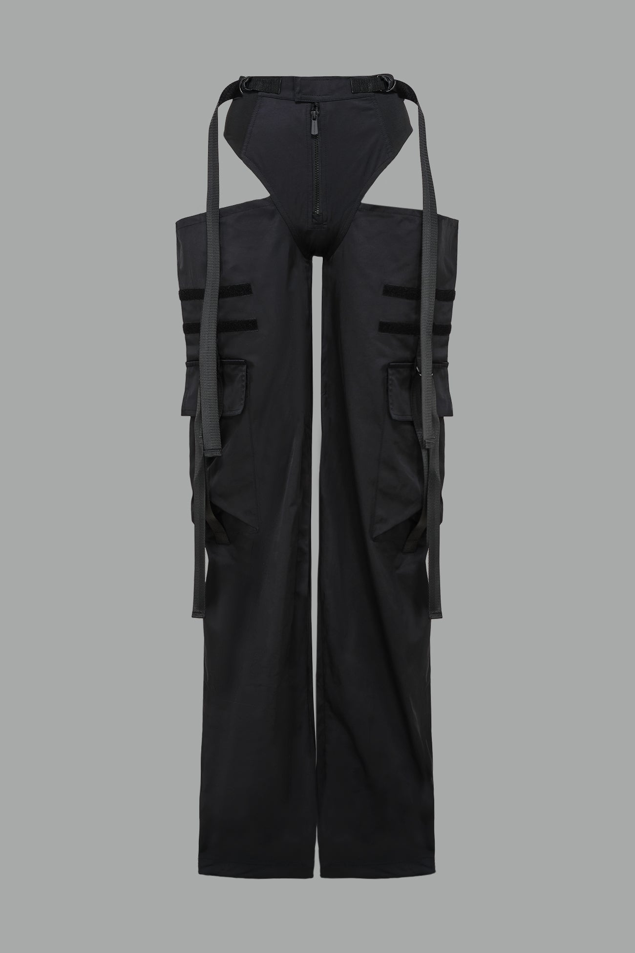 Black nylon cargo trousers with exposed high-cut panty waist, cut-out hips, oversized pockets, and adjustable utility straps – edgy streetwear and festival pants.