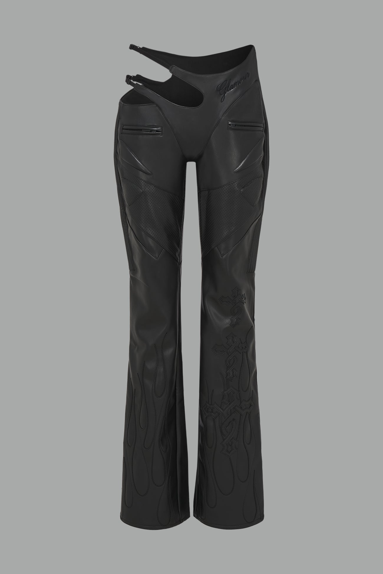 black vegan leather flare trousers with motocross paneling, padded details, flame and cross stitching, slogan embroidery, and an asymmetric waistband with adjustable elastic thong straps.