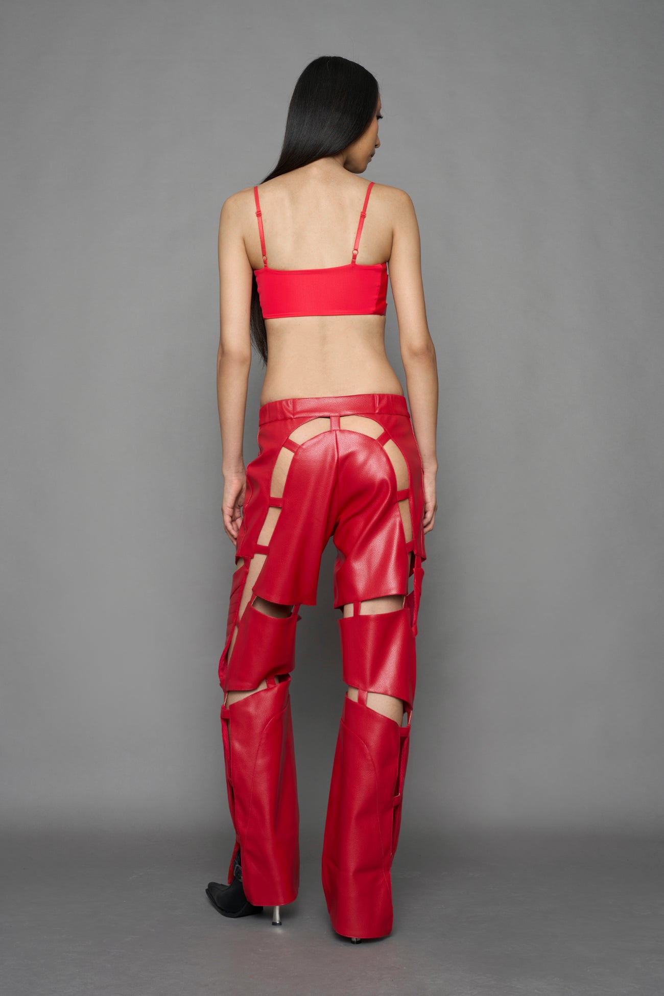 model wearing red vegan leather pants with cut outs