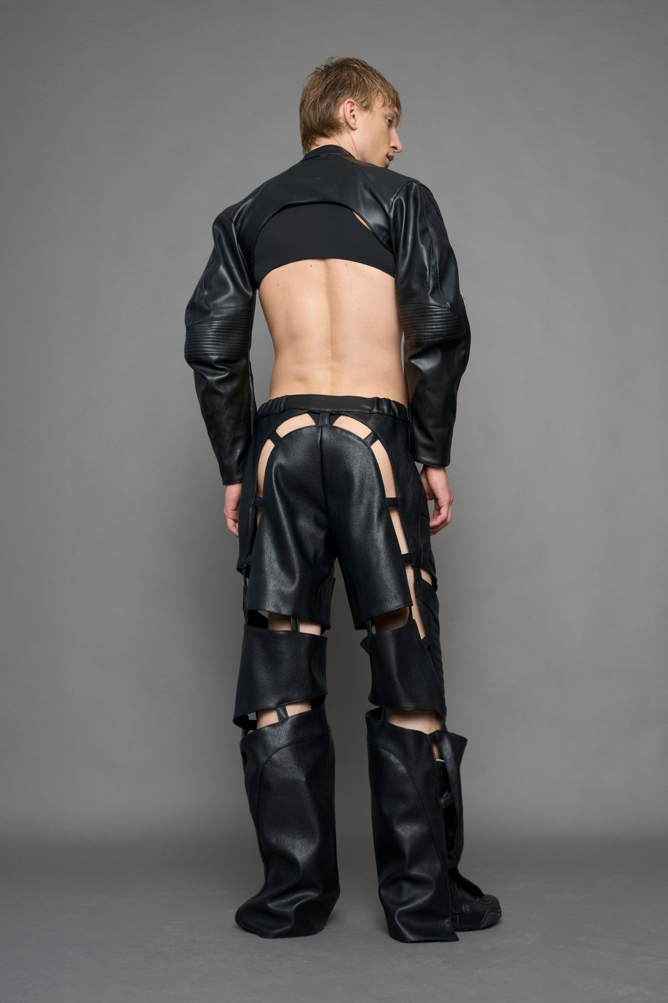 model wearing black vegan leather pants with cu outs