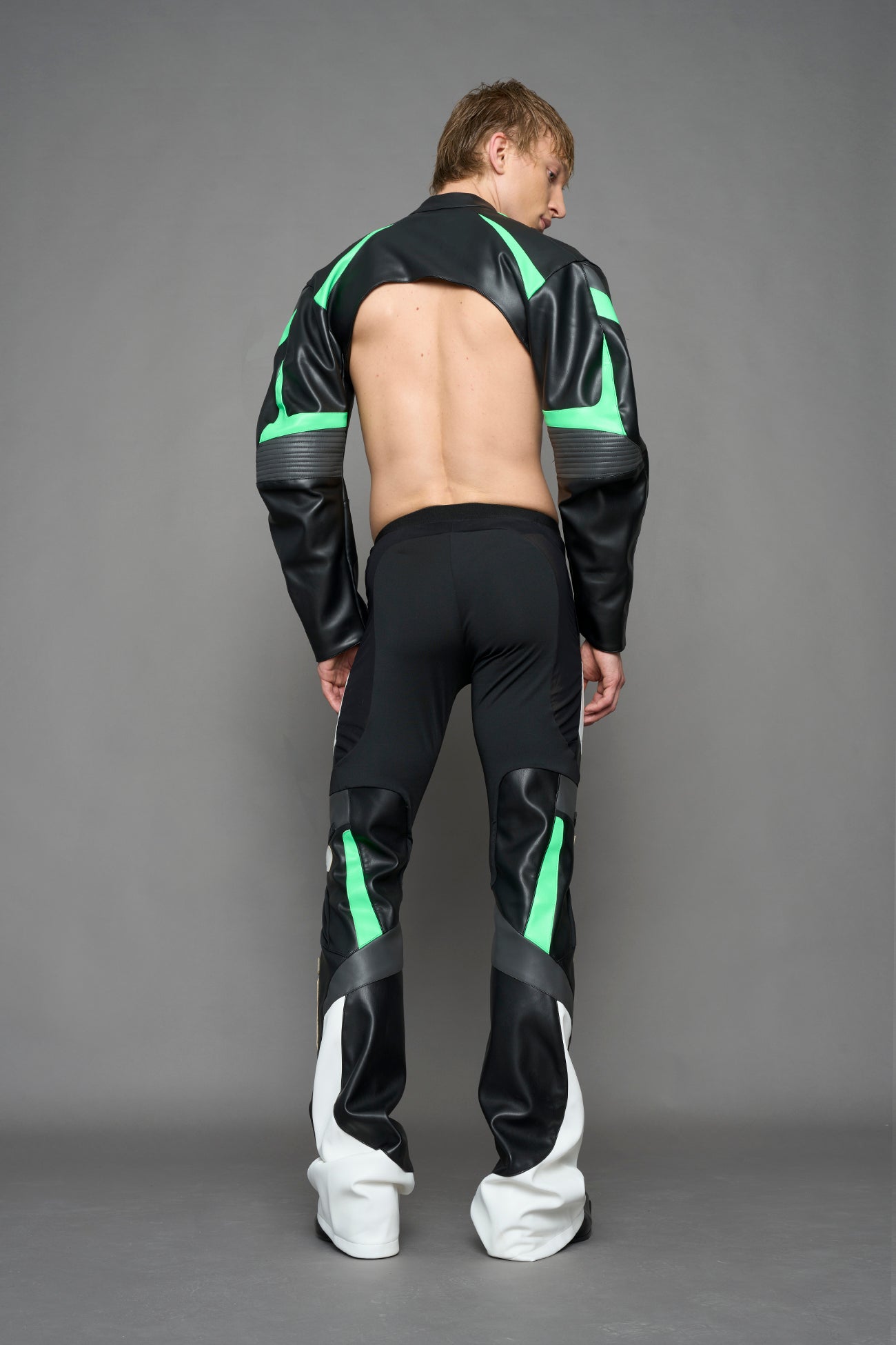model wearing black white and green cropped jacket with logo on the arm