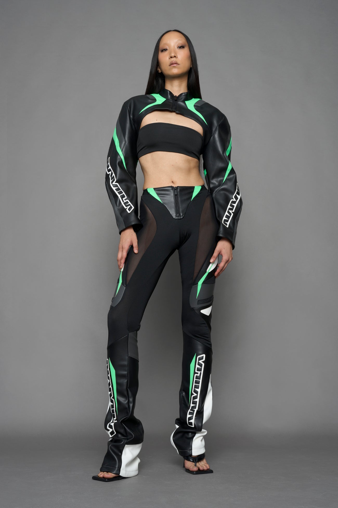 model wearing black white green moto inspired mesh pants with logo on the leg