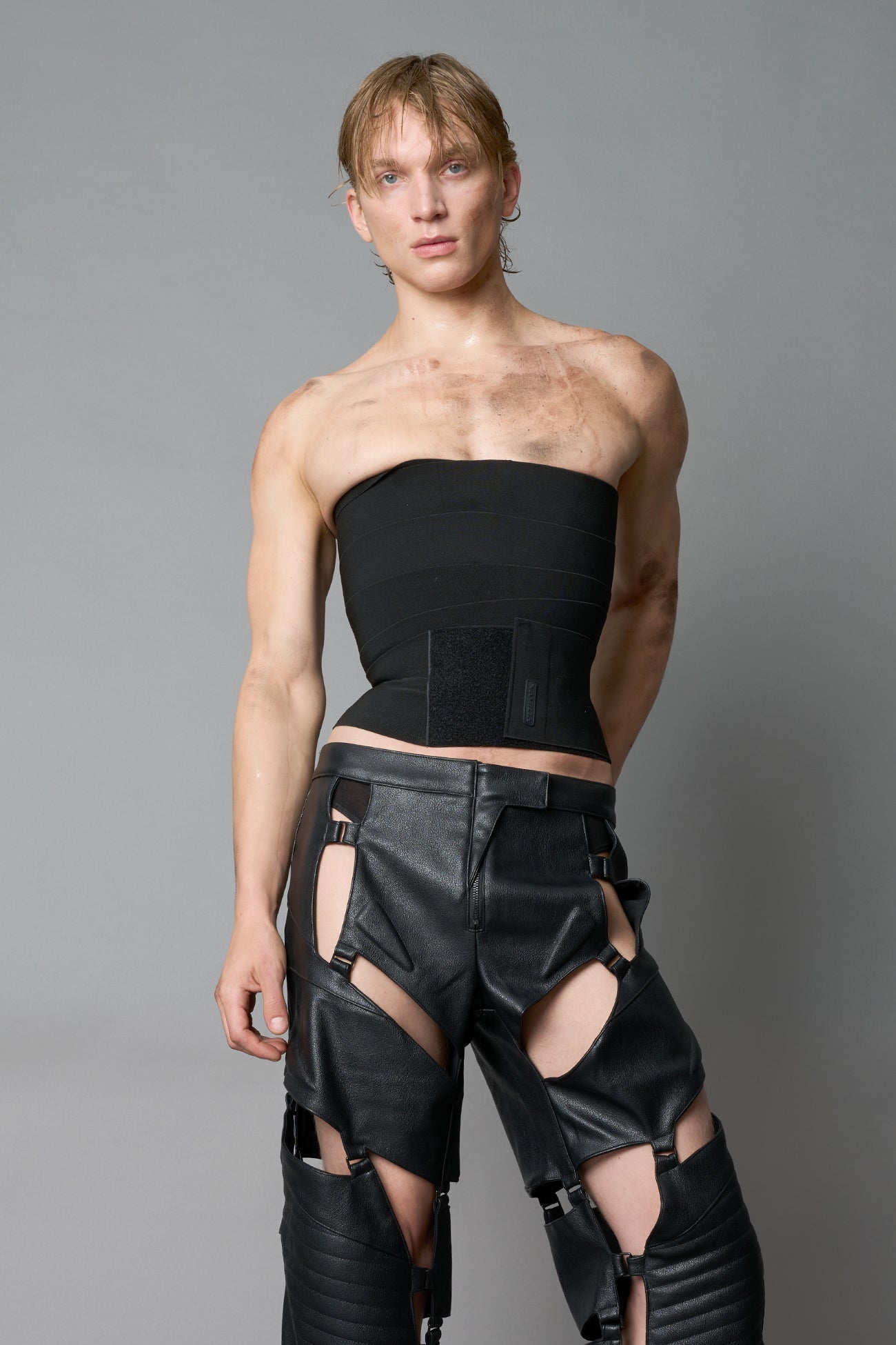 Model wearing black strapless bandage crop top with structured compression fit, edgy Y2K streetwear outfit by Namilia.