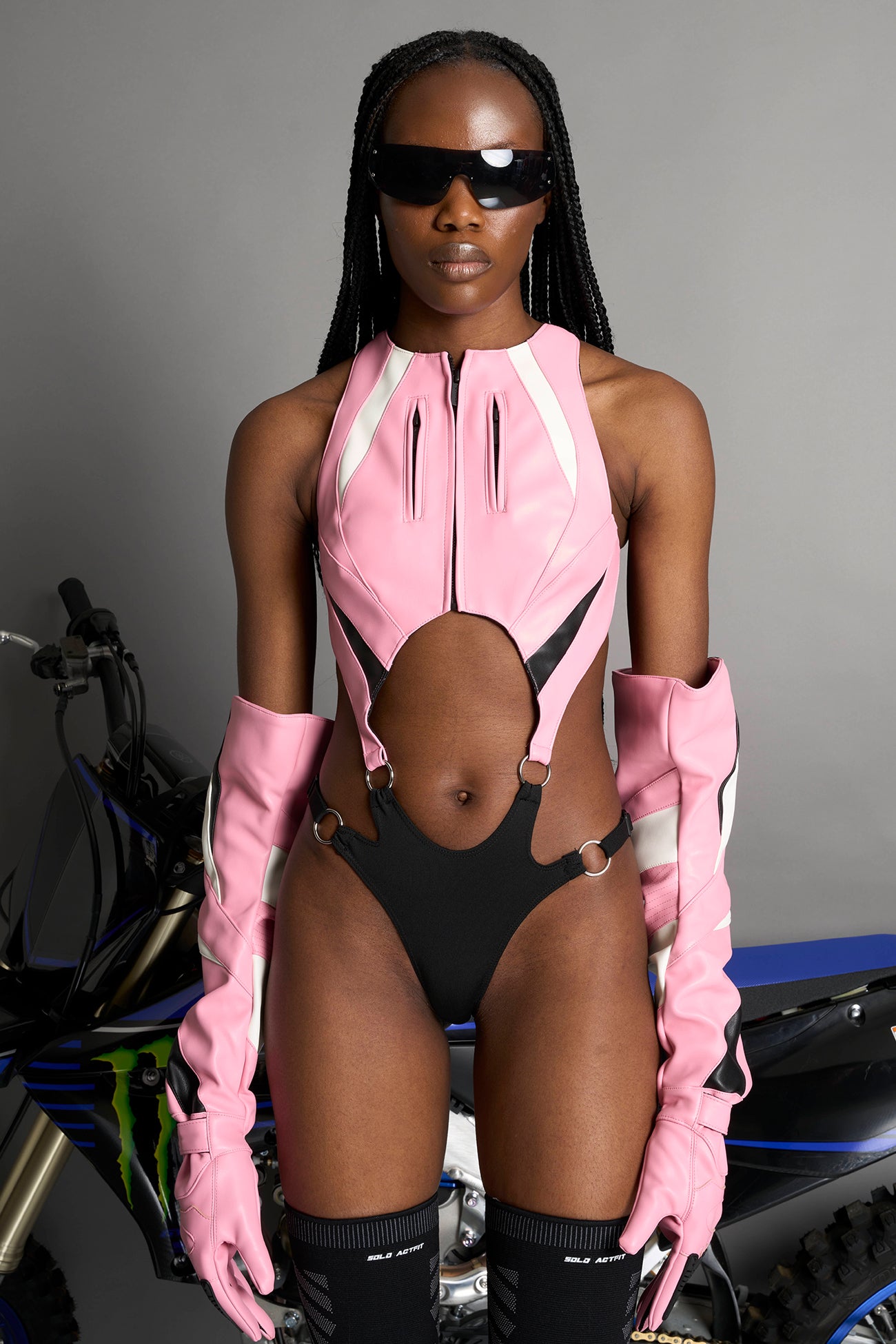 model wearing pink cut out motocross body with string elastic panty part