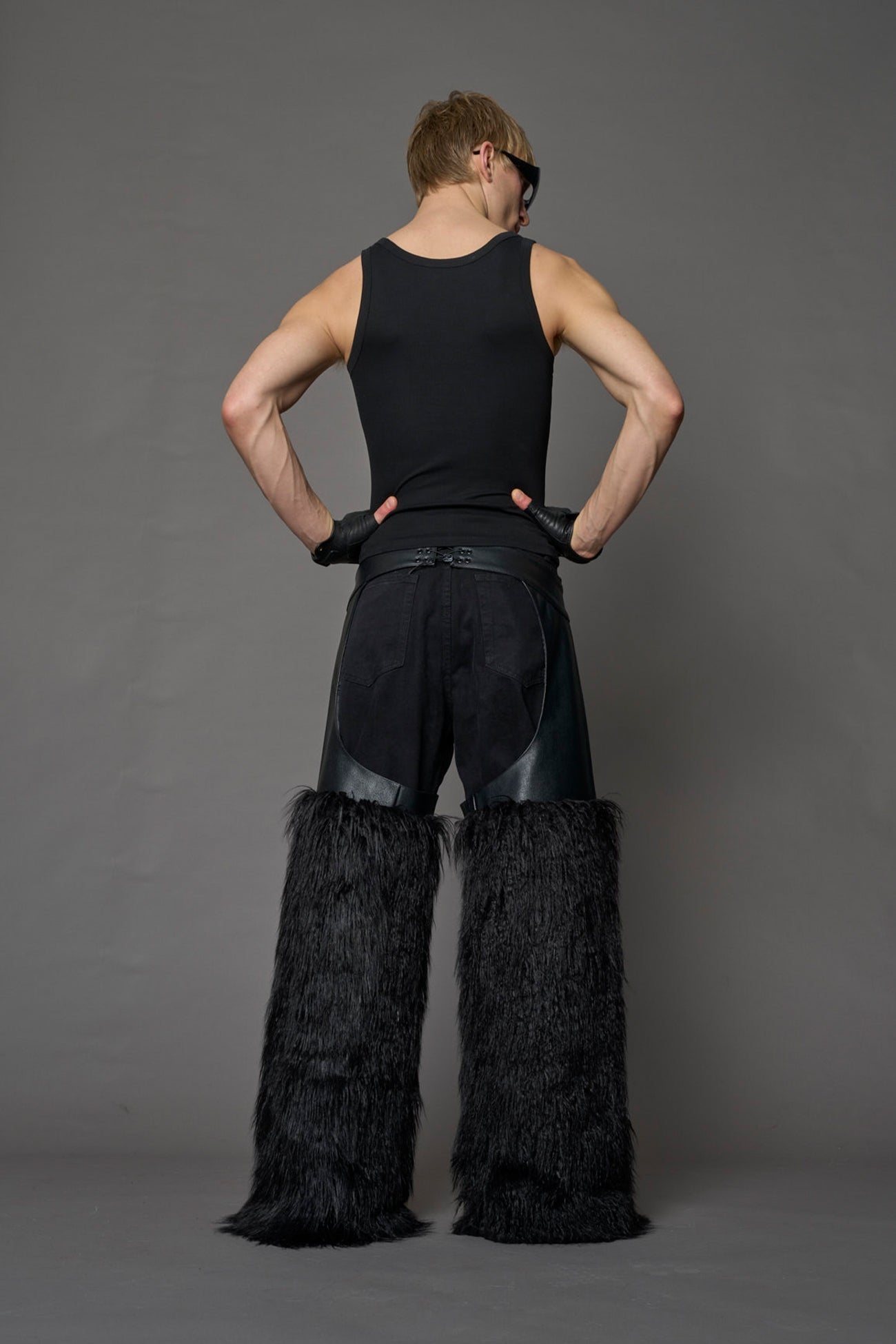 model wearing black vegan leather and faux fur chaps
