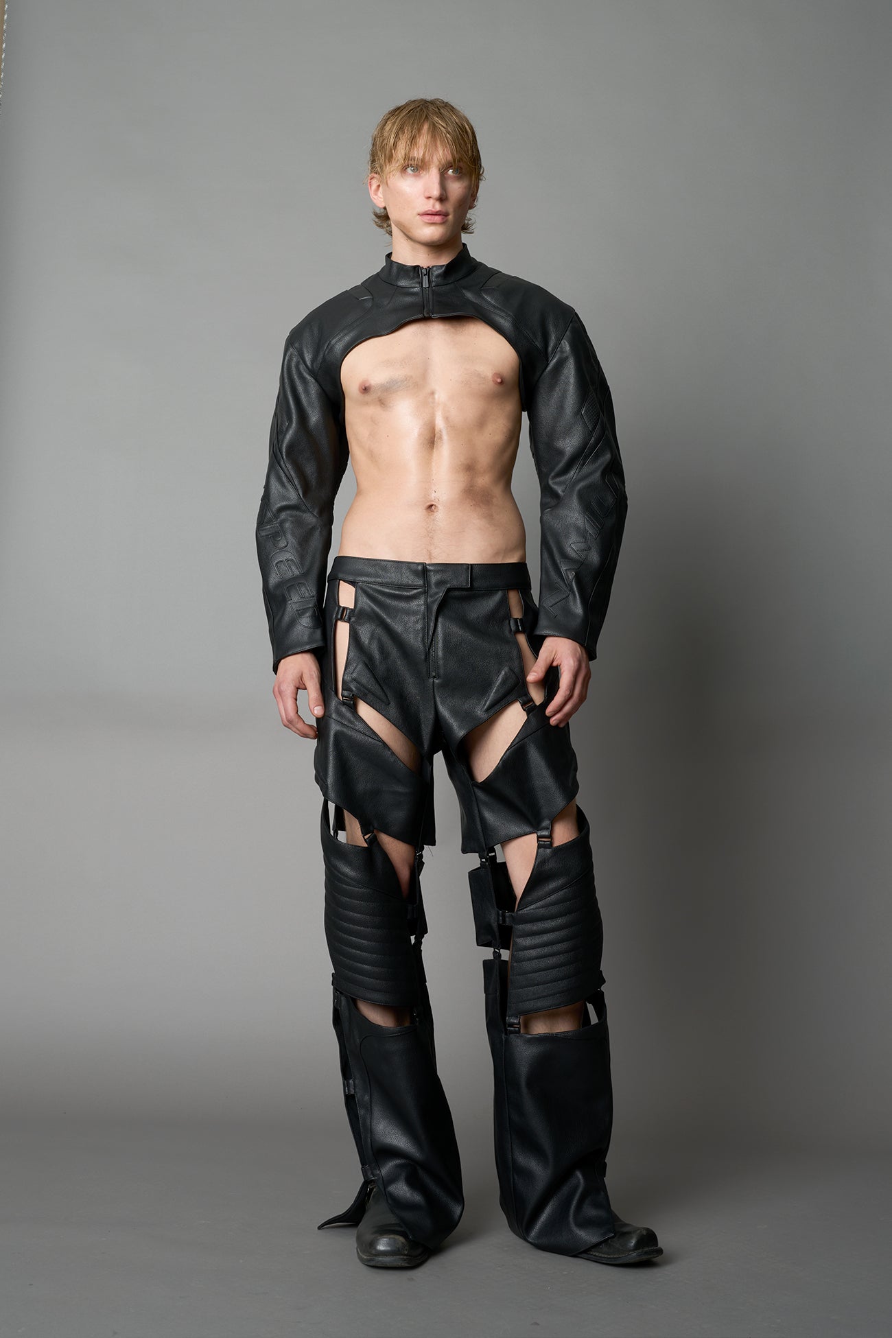 Model wearing a black vegan leather cropped jacket with a high choker collar and zipper front