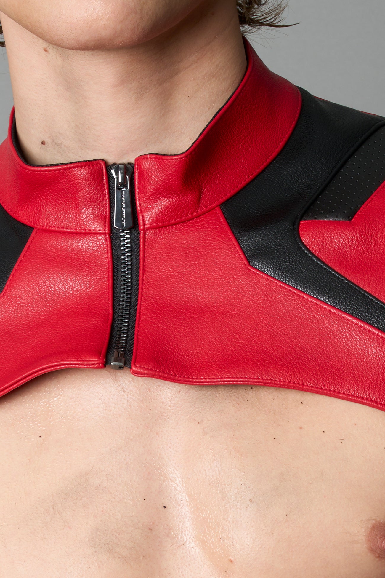 Model wearing a red vegan leather cropped jacket with a high choker collar and zipper front