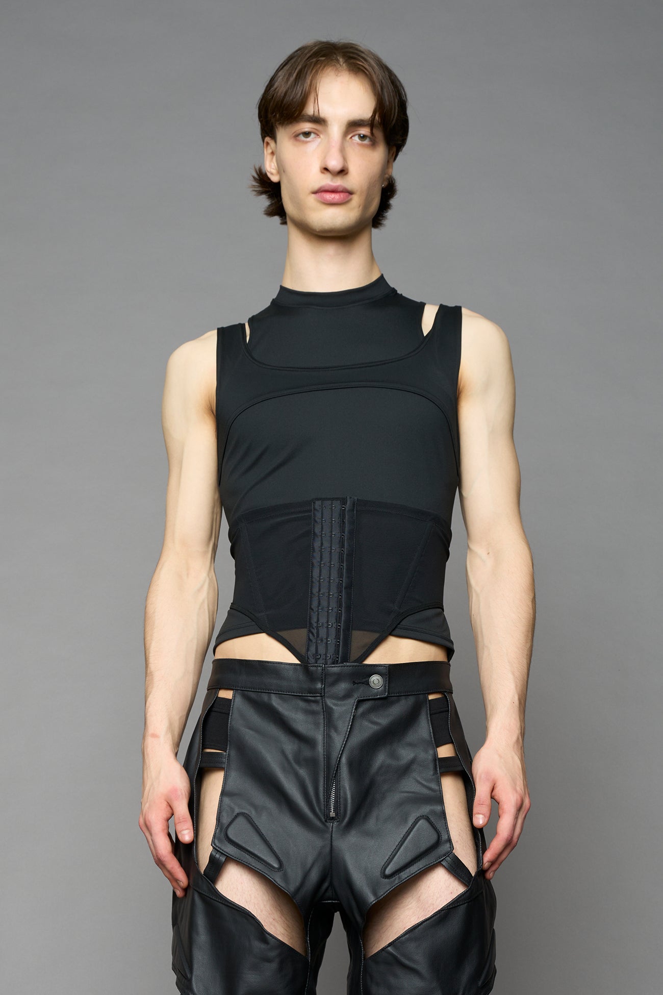 Black contour top by NAMILIA featuring a sculpted fit, corset-style waist with hook-and-eye closure, and high neckline. Statement shaping top.