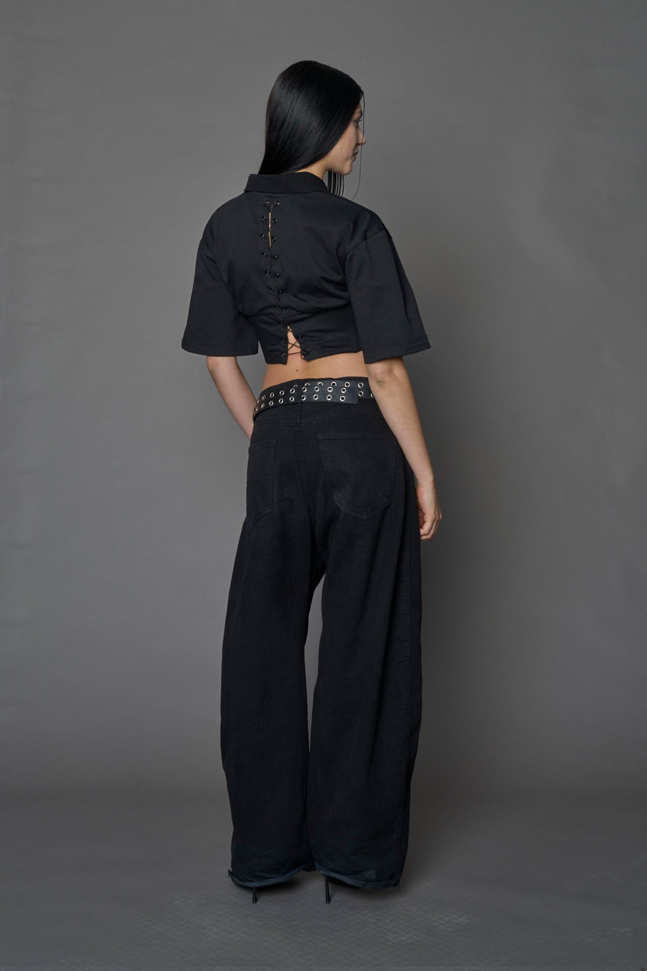 Model wearing a Polo shirt inspired black corset with lacing on the back