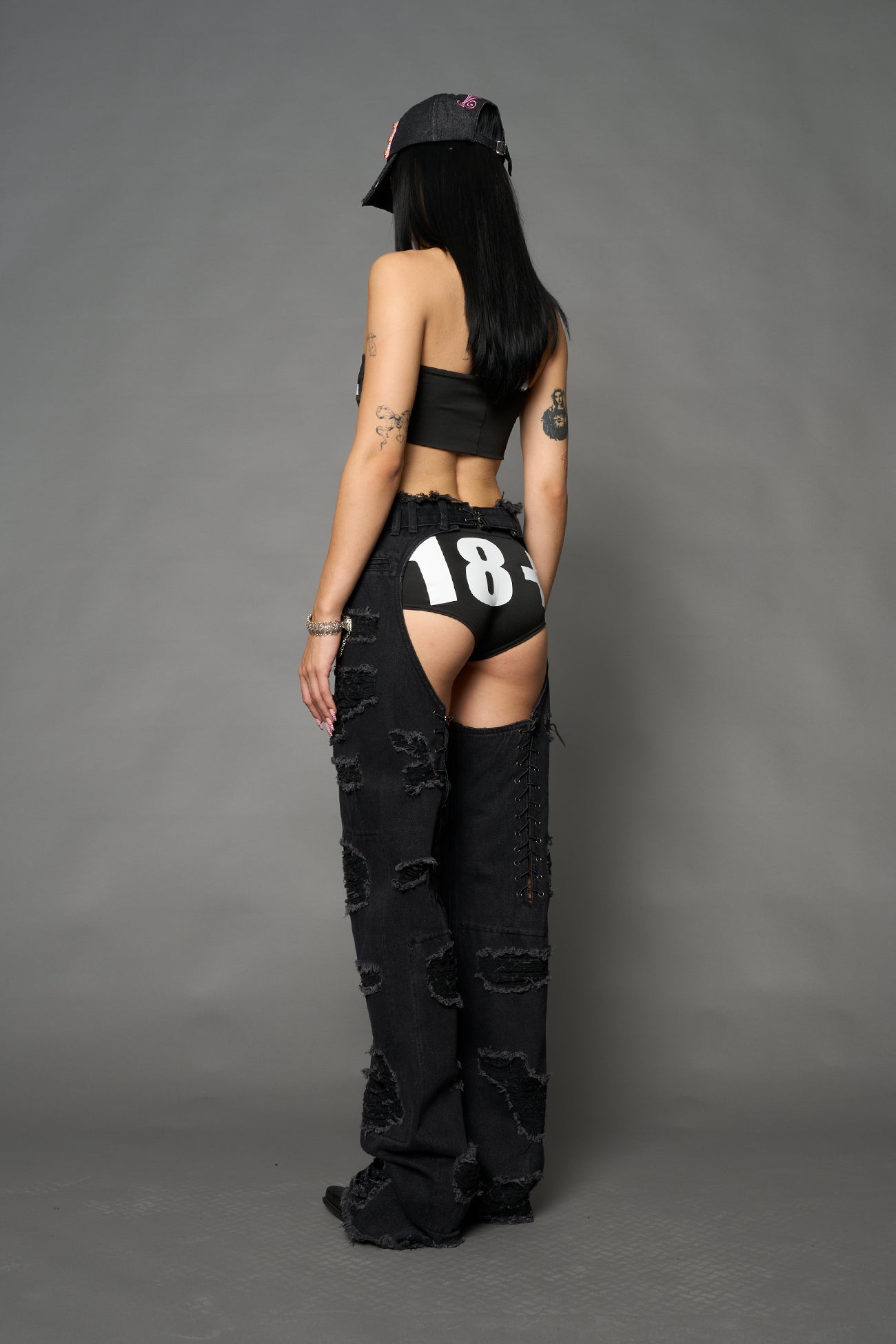 Namilia shredded black denim chaps with low-rise fit, extreme thigh cut-outs and distressed straight legs