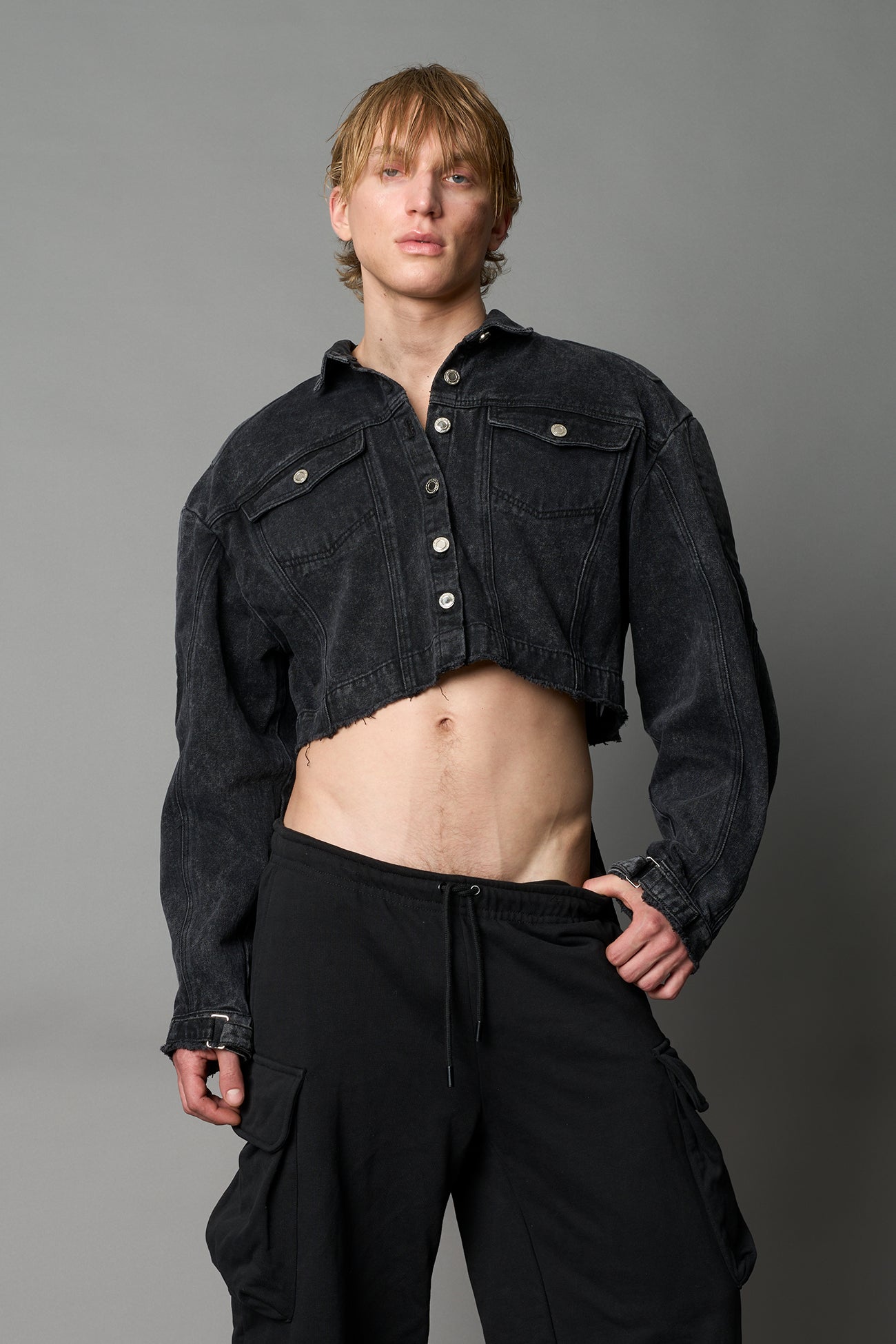 model wearing black washed denim jacket with structured corset waist and moto-style silhouette