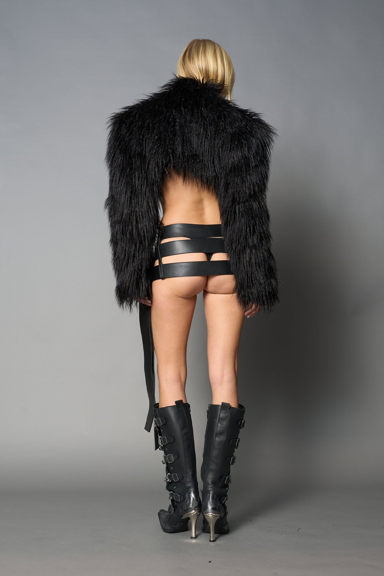 Black cropped faux fur jacket with exaggerated shoulders and high neck – bold statement outerwear for nightlife, streetwear, or runway looks.