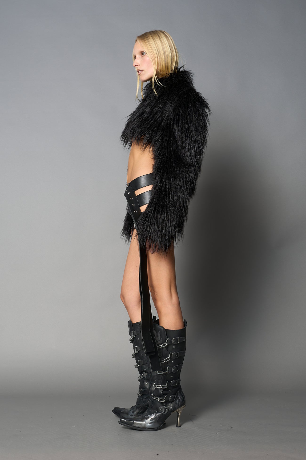 Black cropped faux fur jacket with exaggerated shoulders and high neck – bold statement outerwear for nightlife, streetwear, or runway looks.