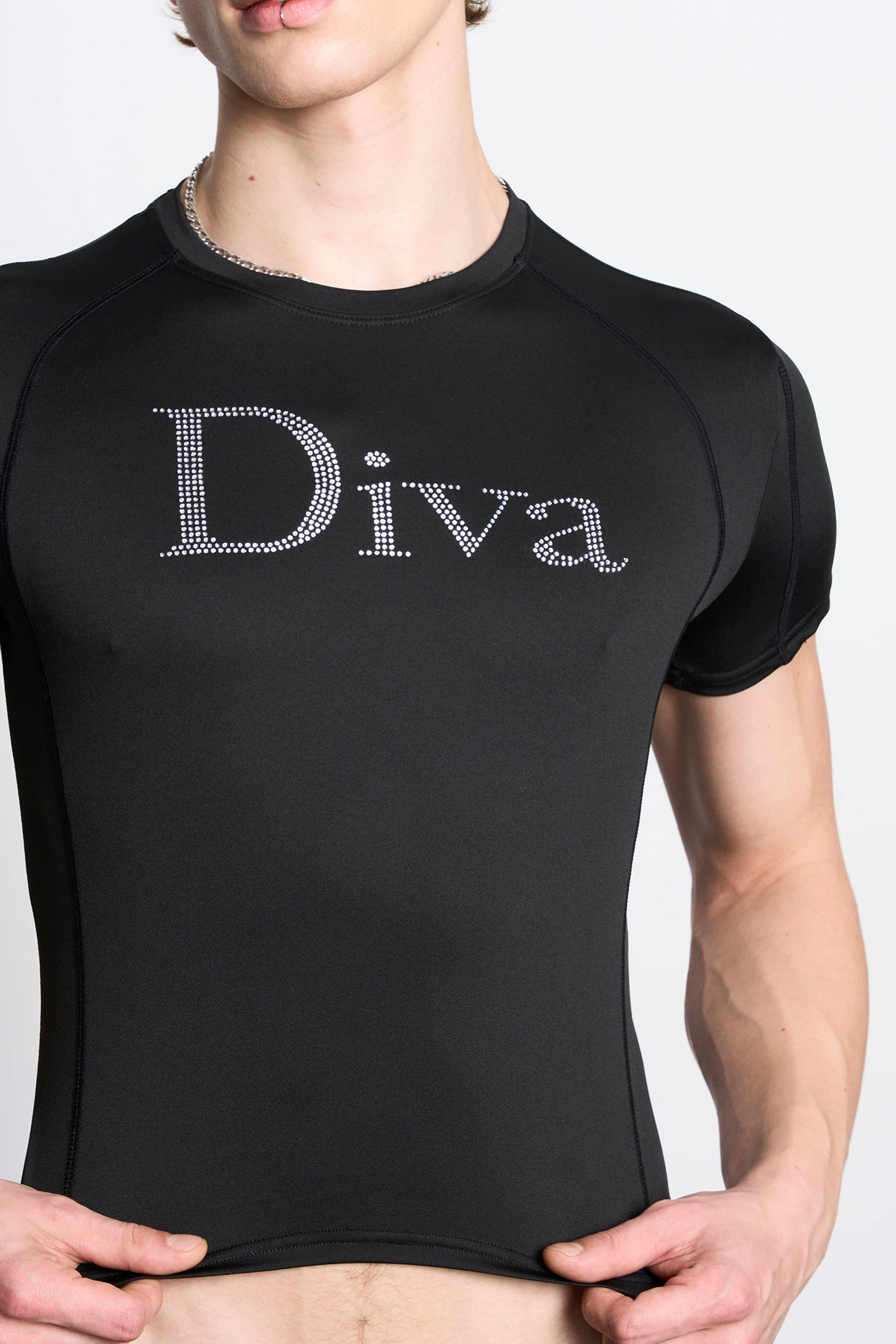 Model wears a black short-sleeved stretch lycra t-shirt with racing-style lines , black coverstitch seams, and a rhinestoned slogan.