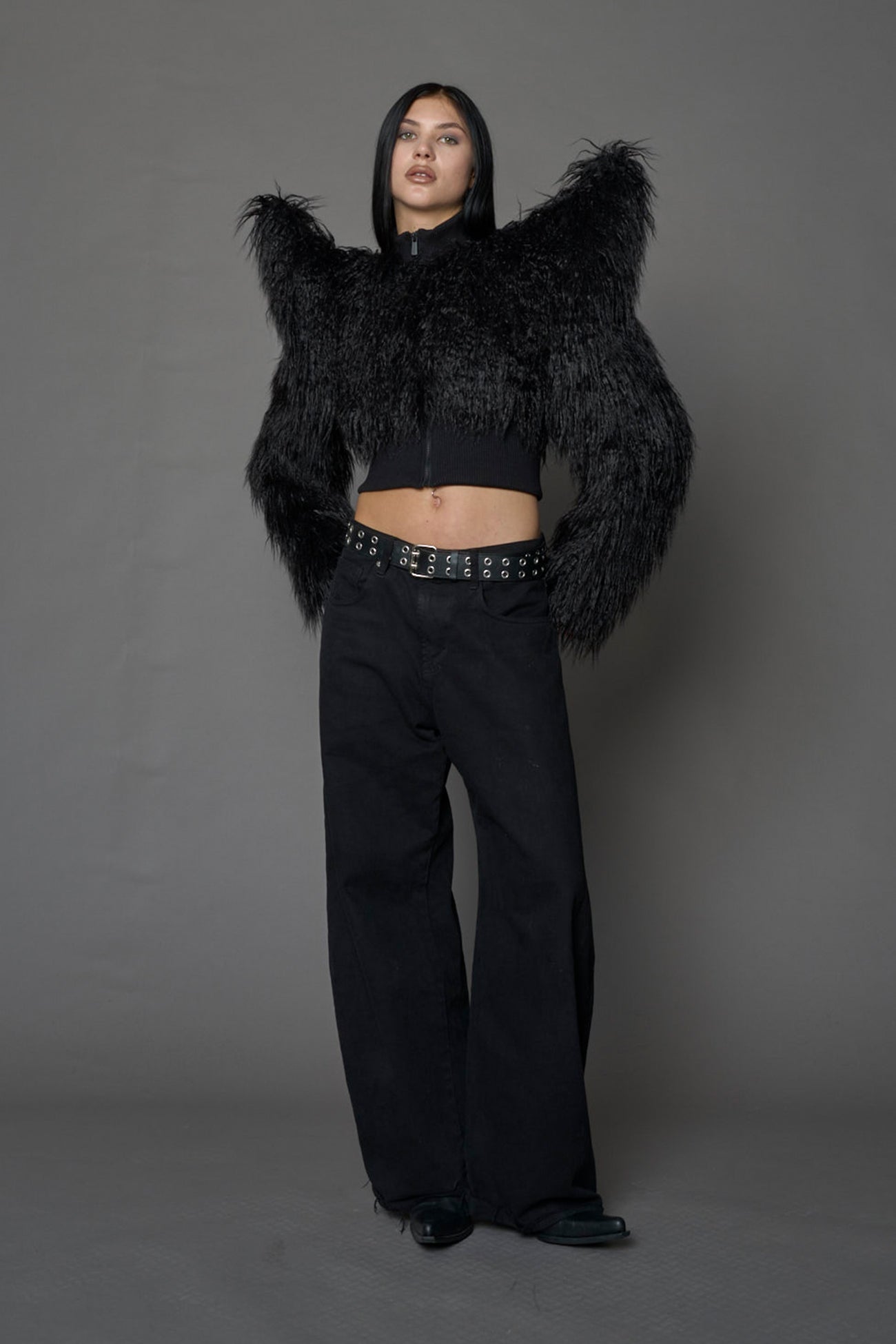 Model wearing black spike shoulder crop faux fur coat