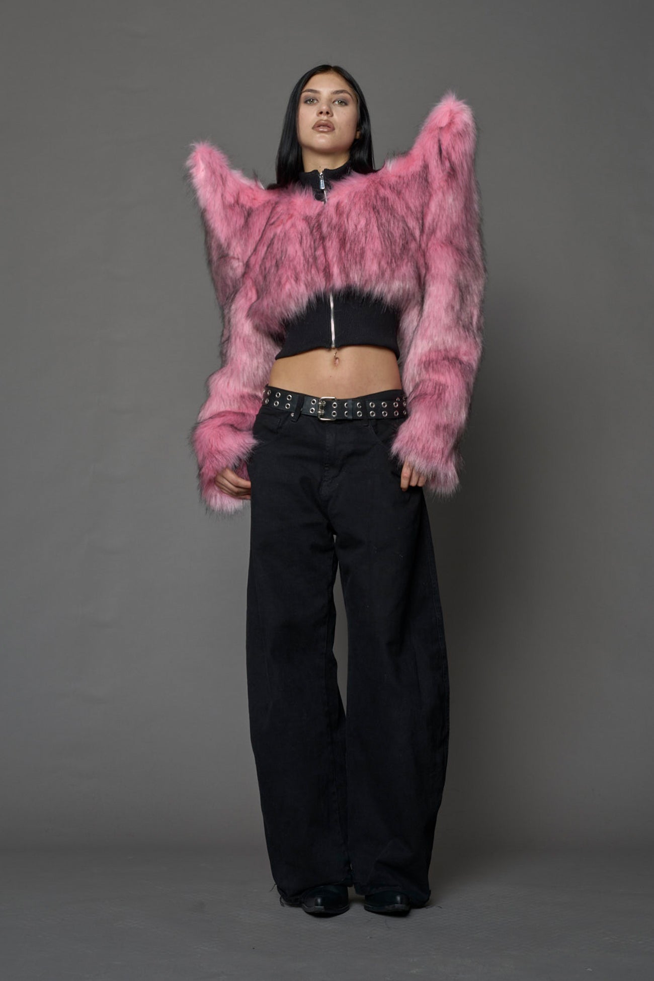 Model wearing pink spike shoulder crop faux fur coat