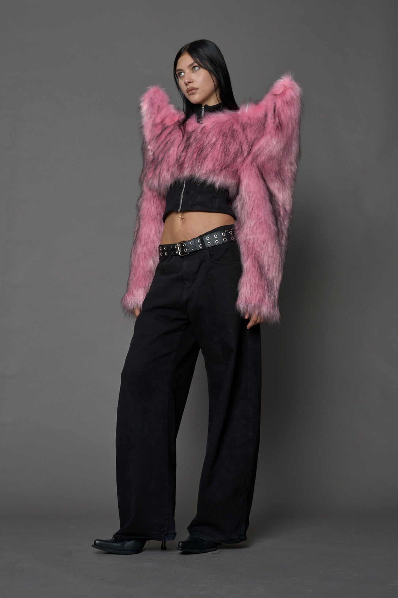 Model wearing pink spike shoulder crop faux fur coat