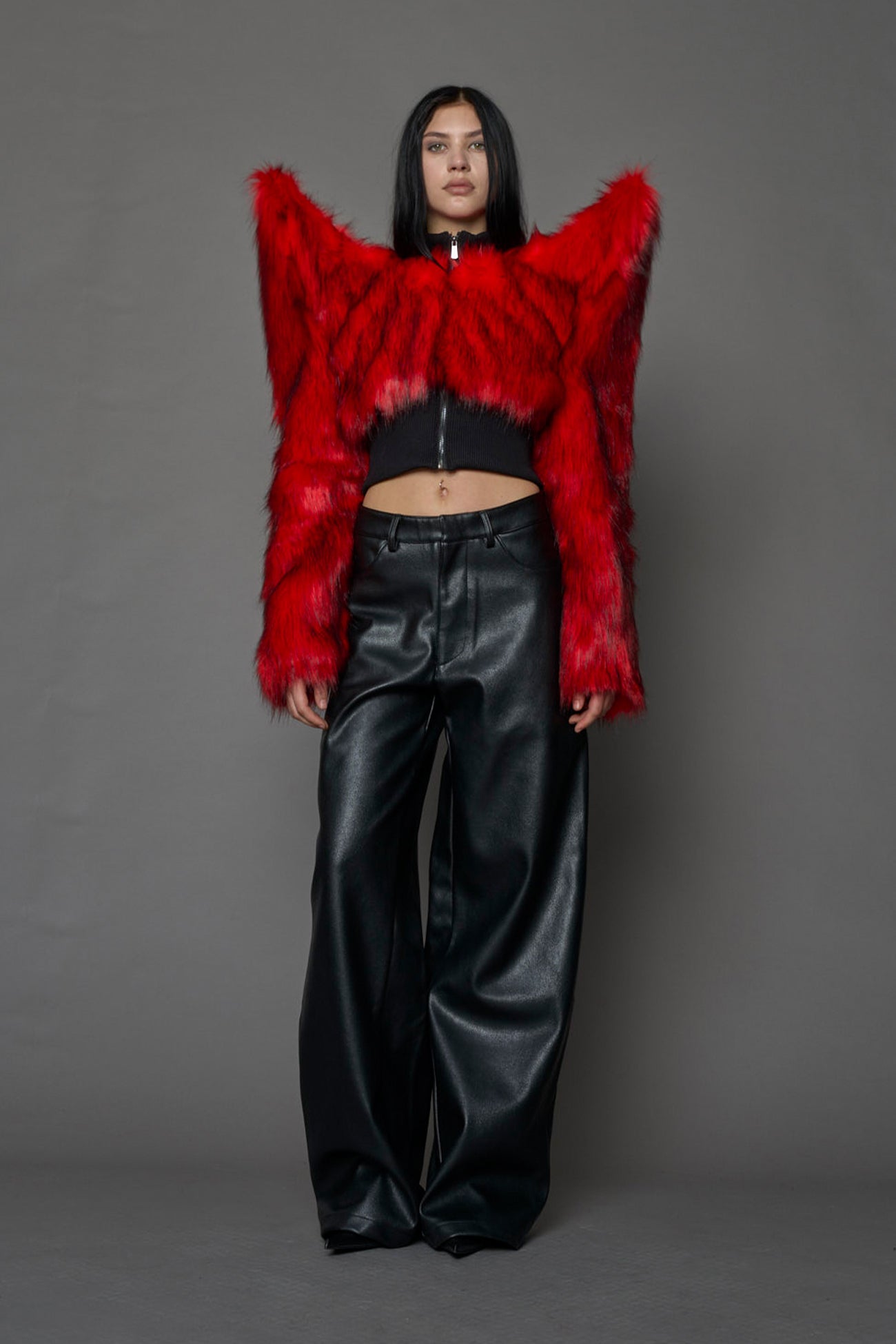Model wearing red spike shoulder crop faux fur coat