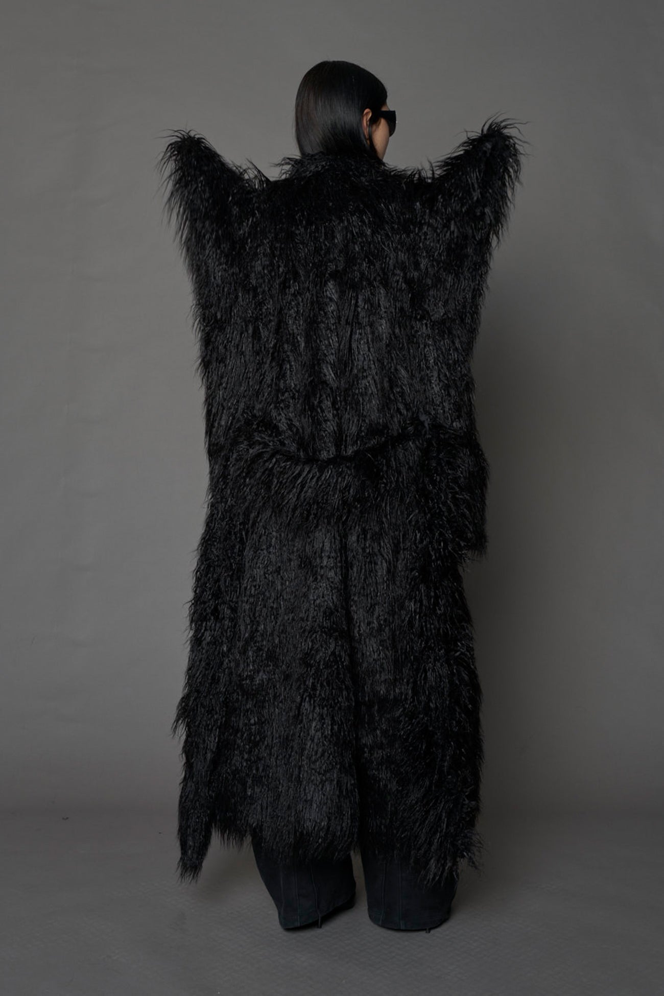 model wearing black spike shoulder long faux fur coat