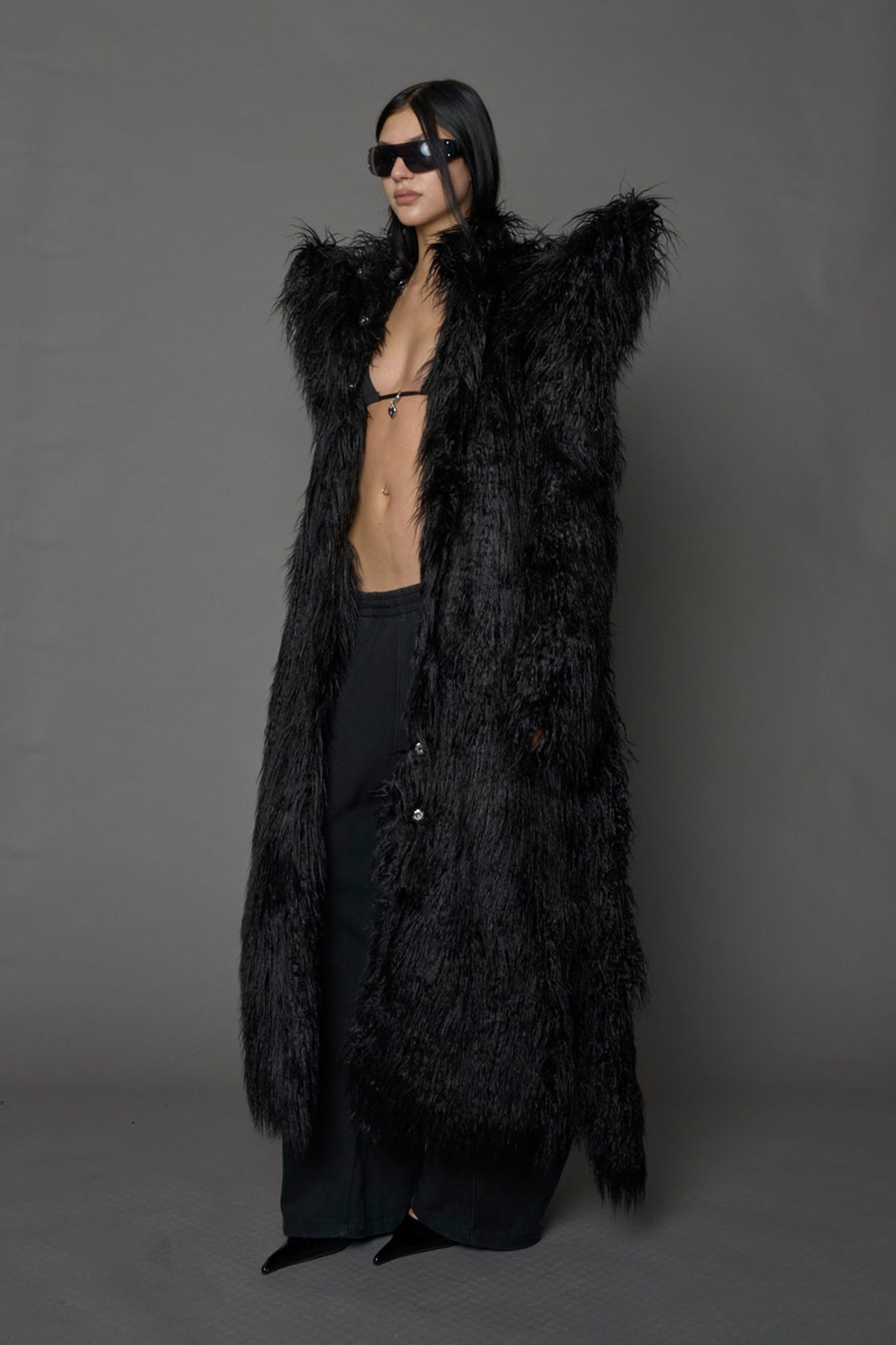 model wearing black spike shoulder long faux fur coat