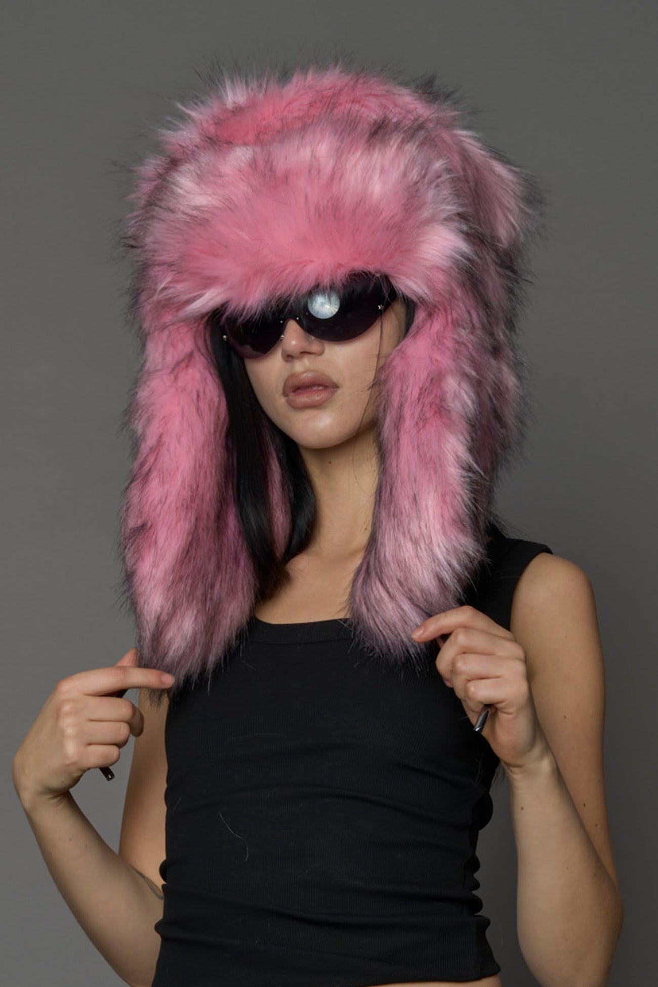 Model wearing oversized pink and cream faux-fur hood hat with drawstrings
