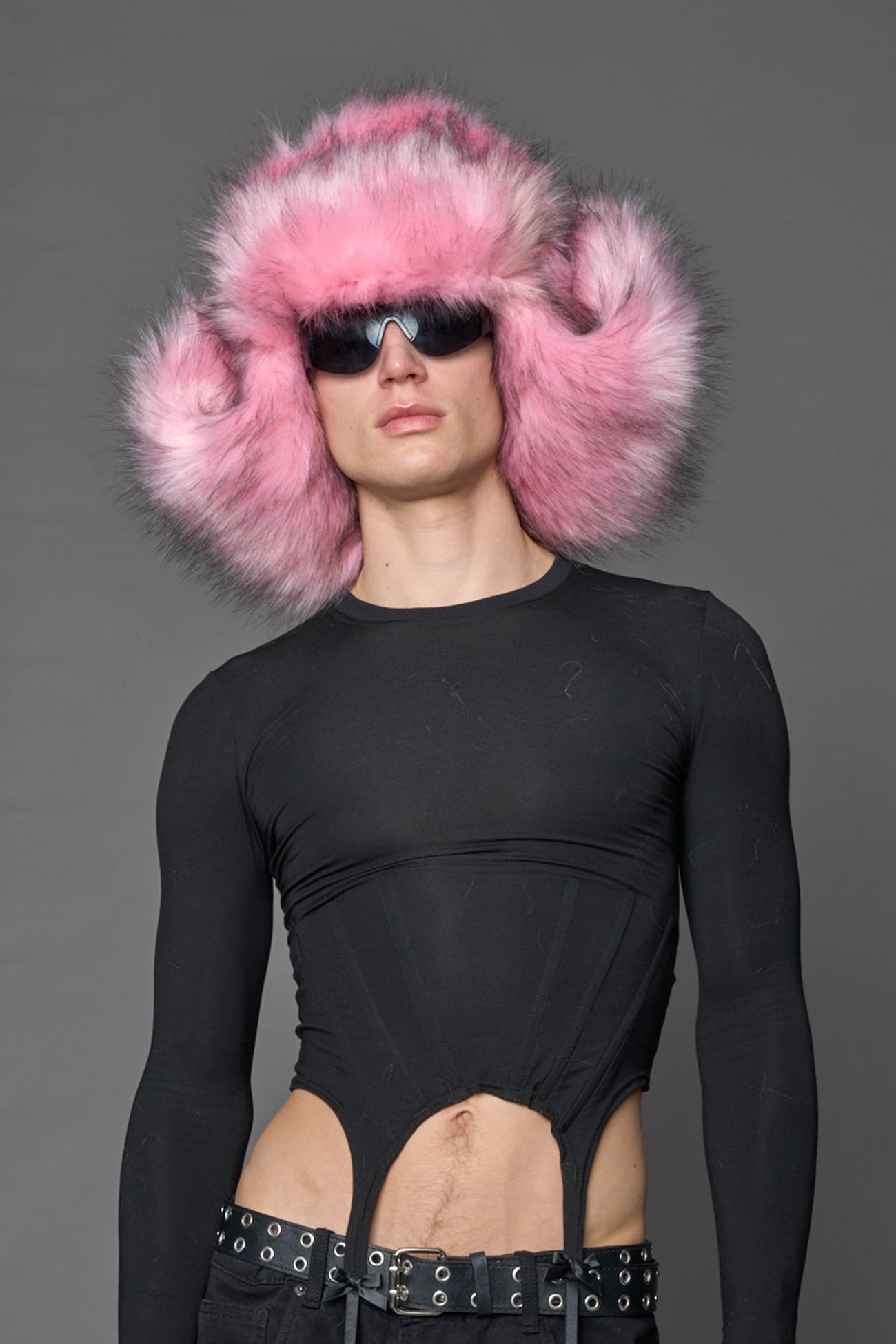 Model wearing oversized pink and cream faux-fur hood hat with drawstrings