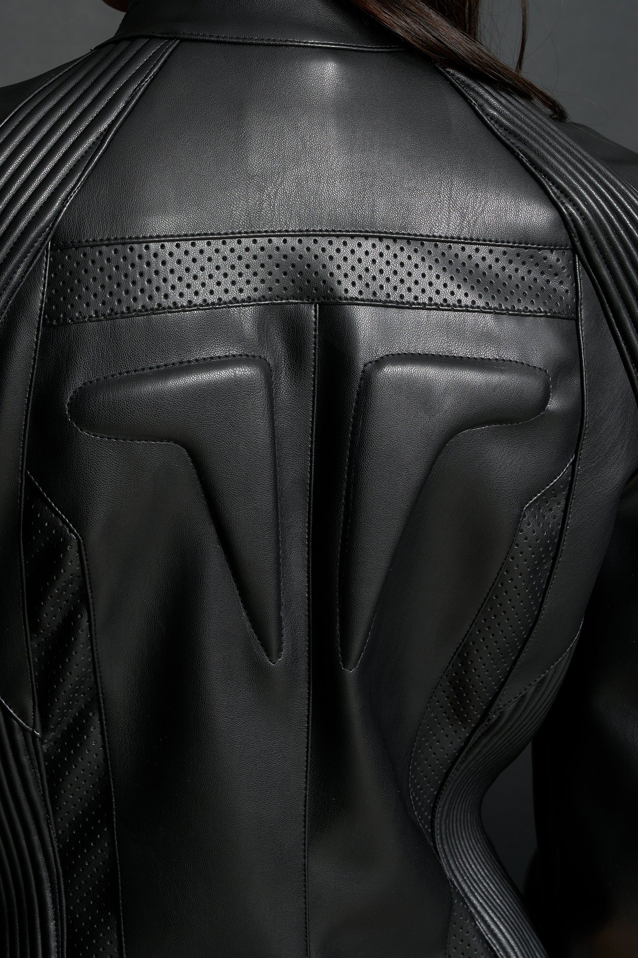 Model wears a motocross jacket-style vegan leather bodysuit with black motocross paneling, padded details, flame graphics, and ‘Hollywood Angel’ embroidery