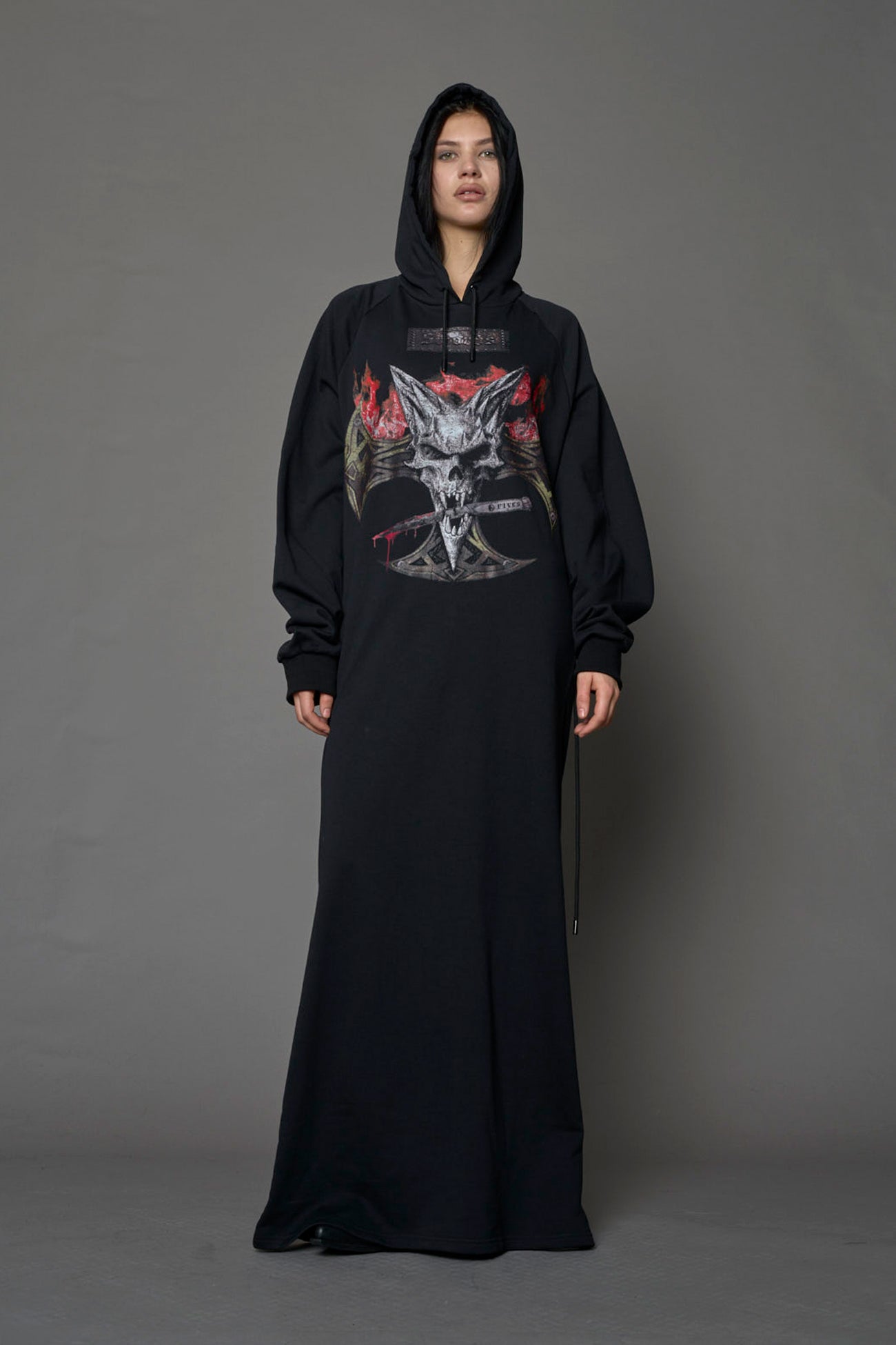 Model wearing a long black hoodie dress with a goth-inspired print detail