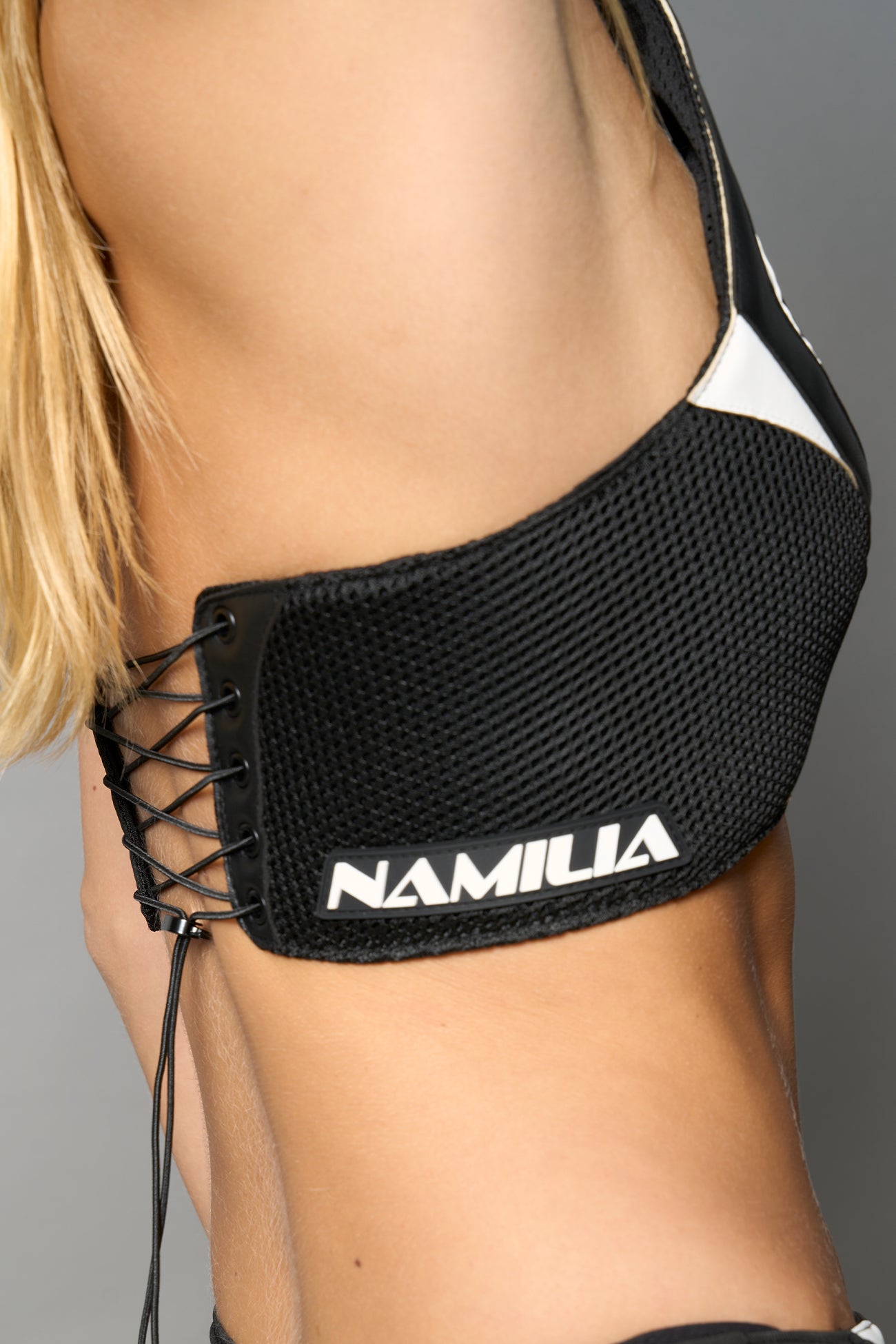 white vegan leather neckholder crop top with lace-up front, high neck collar, and mesh panel detailing – edgy moto-inspired top for clubwear or streetwear.