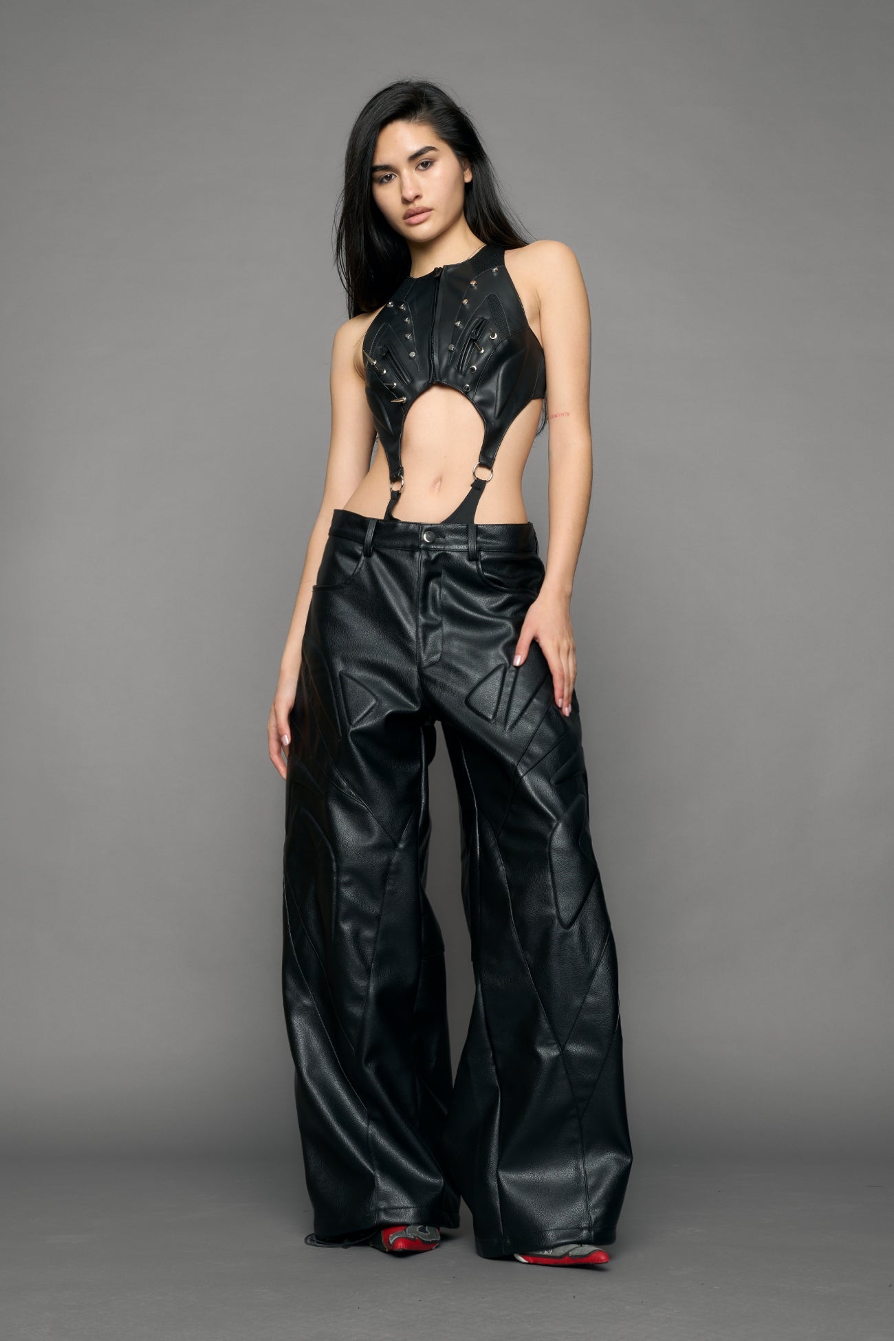 model wearing black oversize pu leather pants with moto style highlights