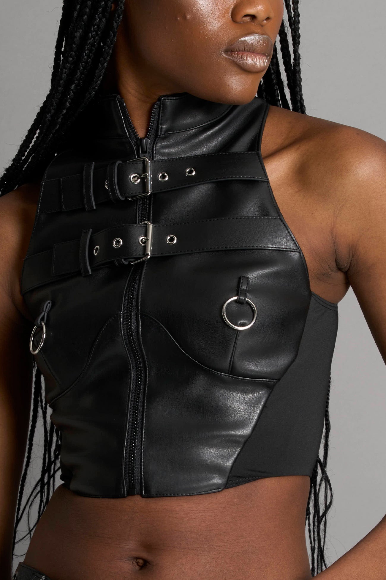 Namilia Piercing Top in black vegan leather featuring silver metal ring details, cutout design, and edgy Y2K-inspired crop top style. front view