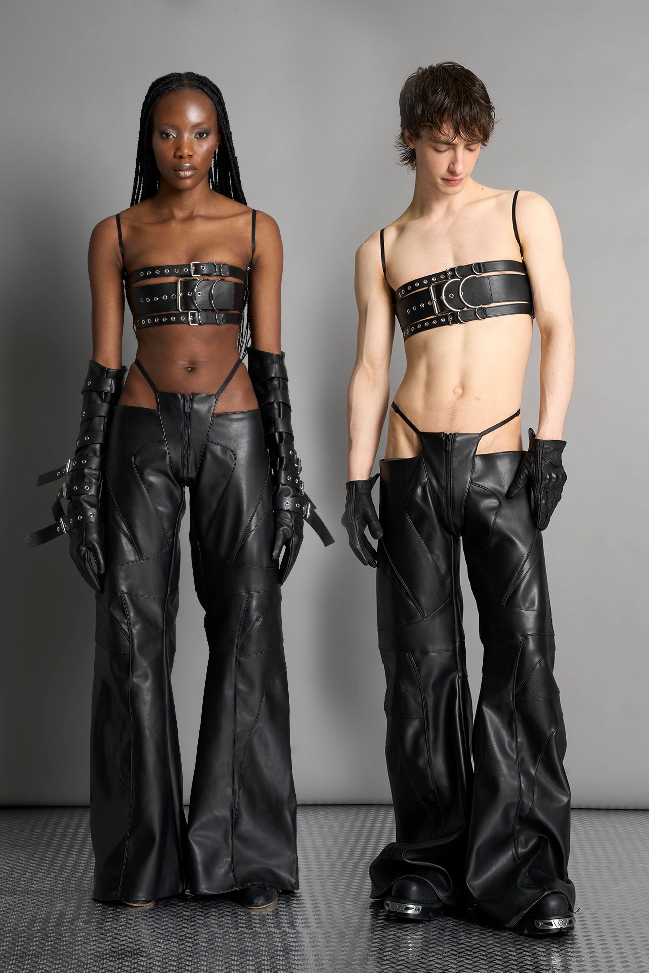 Low-rise flared pants in black faux leather with bold side cut-outs and thong strap detailing. Featuring moto-style paneling, front zip closure, and a sculpted fit. A statement piece for rave, nightlife, and runway-inspired looks.